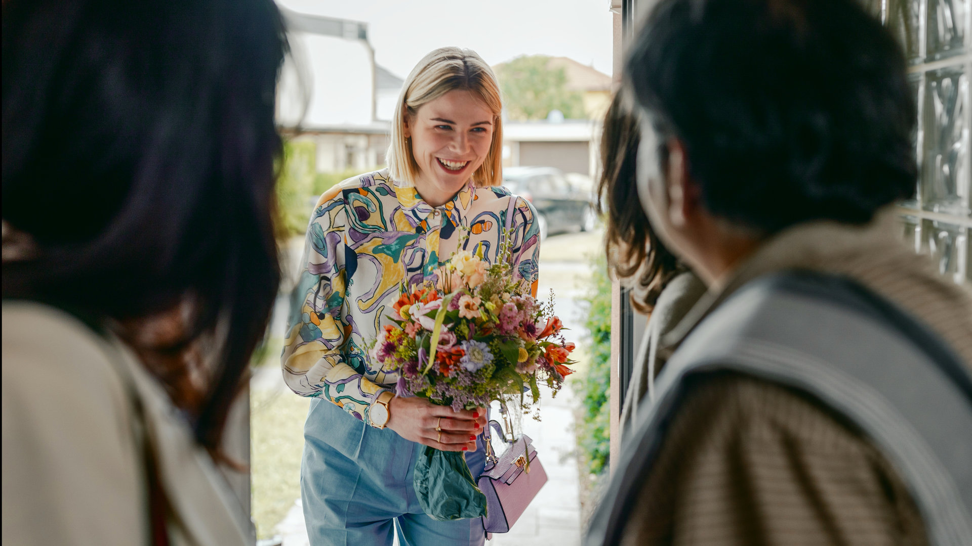 "Deadlines - Happy Bayram": Franzi (Llewellyn Reichman) überreicht den Eltern ihrer Freundin Blumen als Gast-Geschenk.