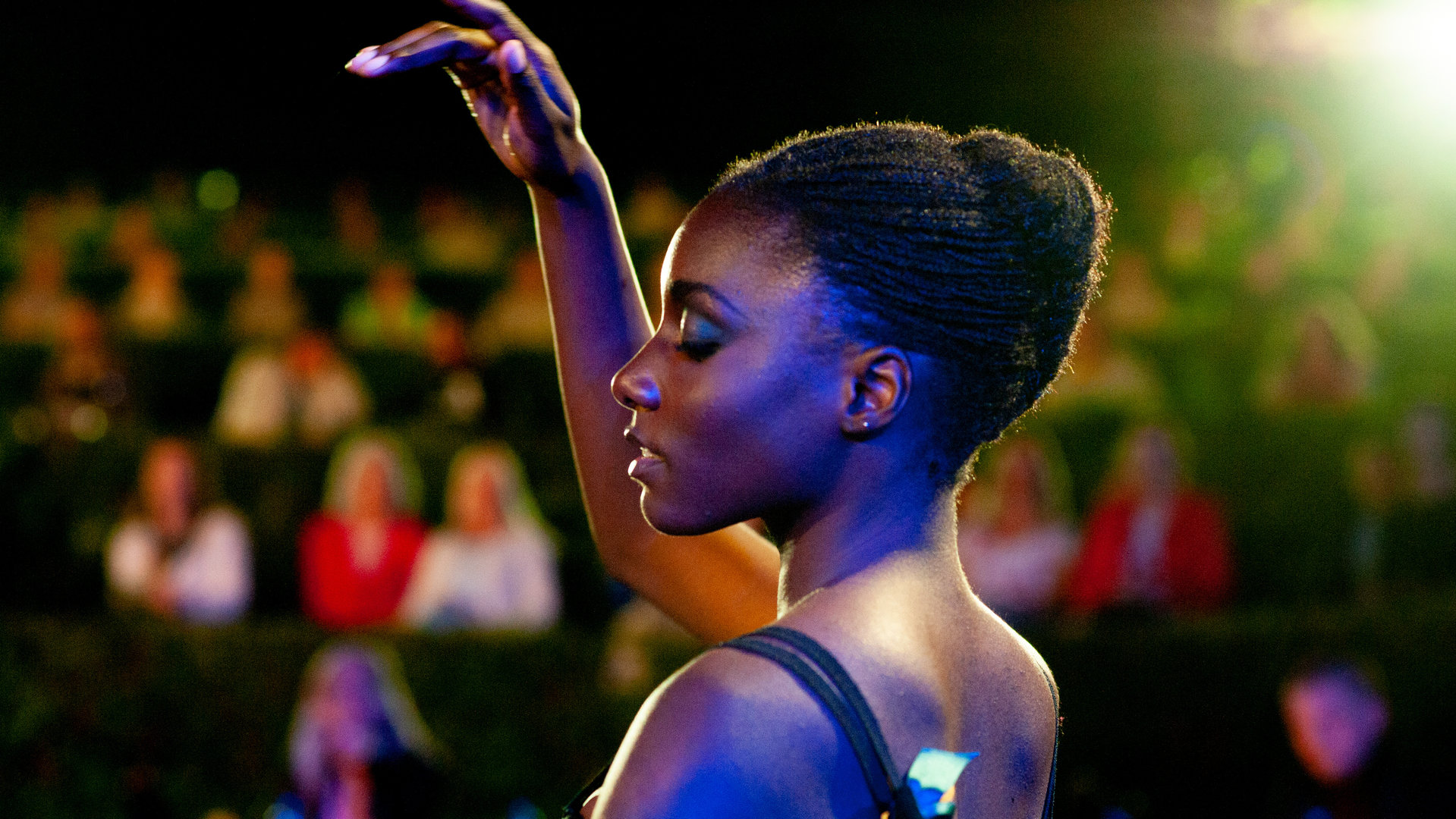 "L´Opéra - Dancing in Paris - Auserwählt": Flora (Suzy Bemba) tanzt konzentriert auf einer Freilichtbühne vor einigen Zuschauern.