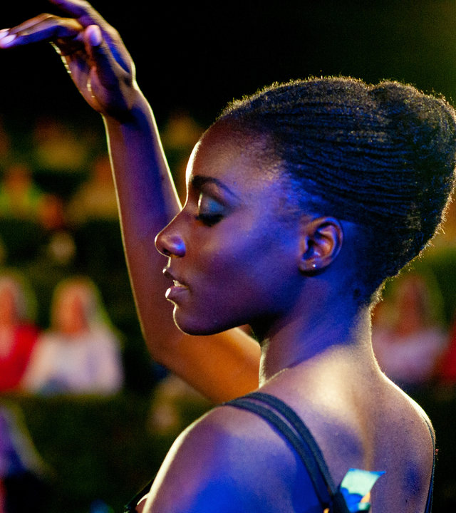 "L´Opéra - Dancing in Paris - Auserwählt": Flora (Suzy Bemba) tanzt konzentriert auf einer Freilichtbühne vor einigen Zuschauern.