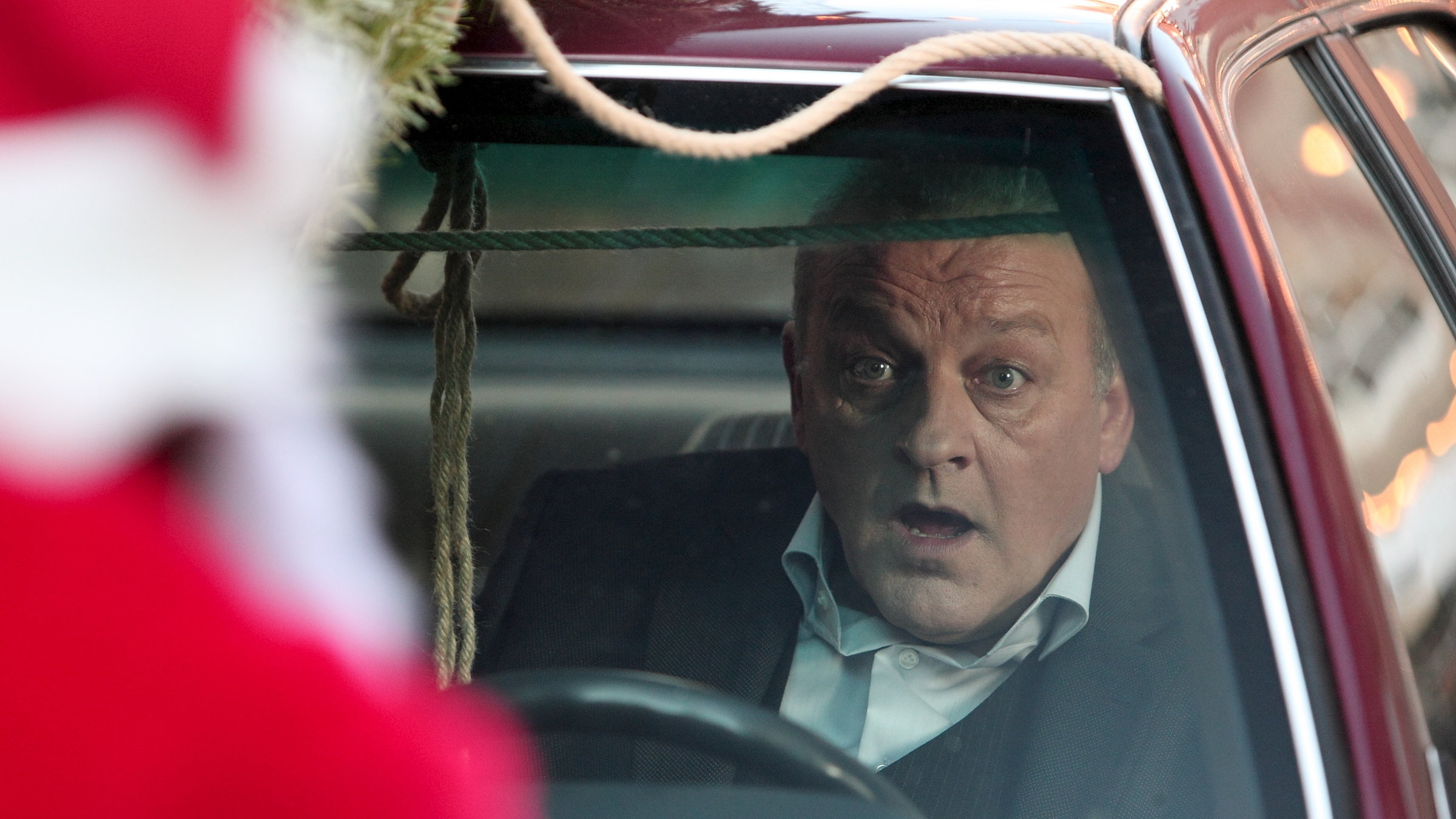 "Wilsberg - Oh du tödliche": Wilsberg (Leonard Lansink) sitzt entsetzt in seinem Auto. Vor dem Auto steht ein Weihnachtsmann.