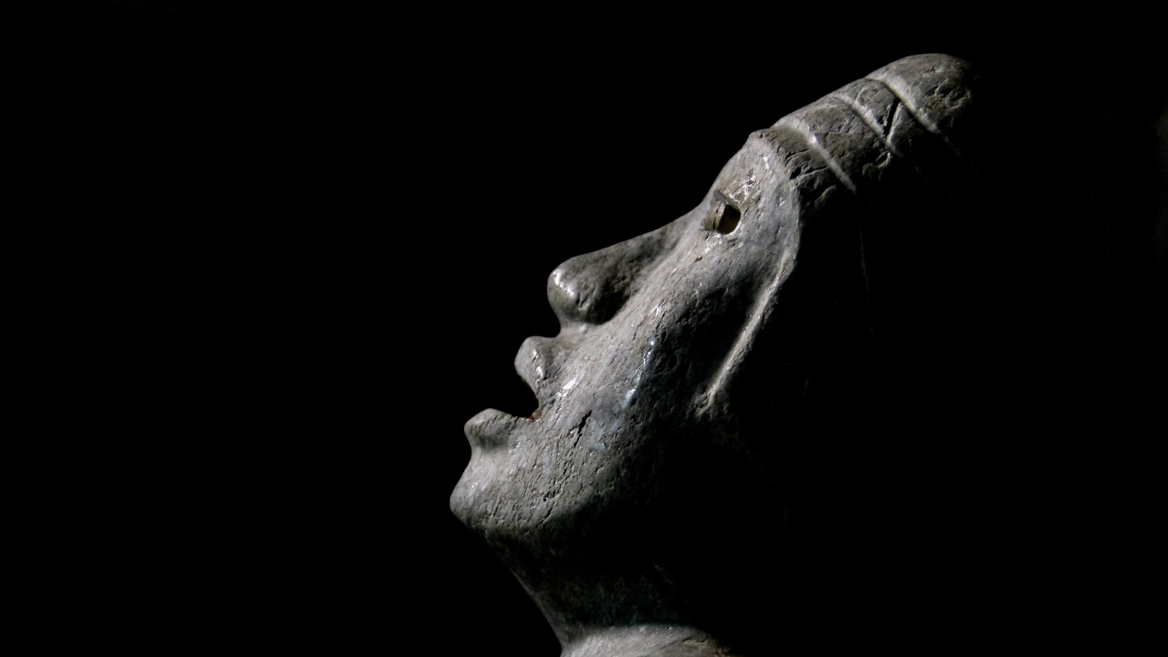 "Terra X: Schätze aus der Unterwelt - Entdeckung in Mexiko": Gesicht einer steinernen Figur vor schwarzem Hintergrund.