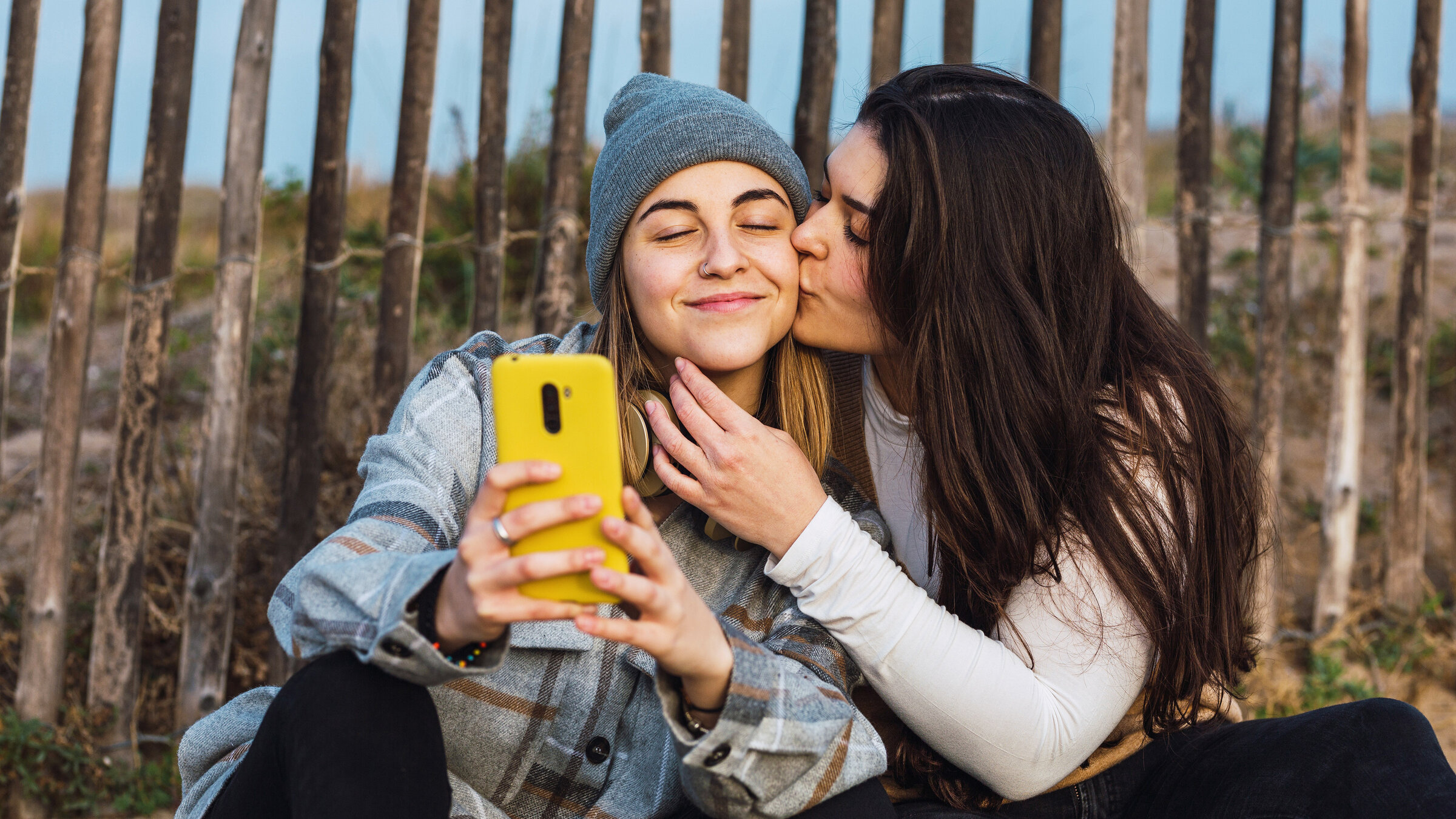 "Liebe und Bindung": Ein Mädchen küsst ein anderes Mädchen auf die Wange, sie machen dabei ein Foto.