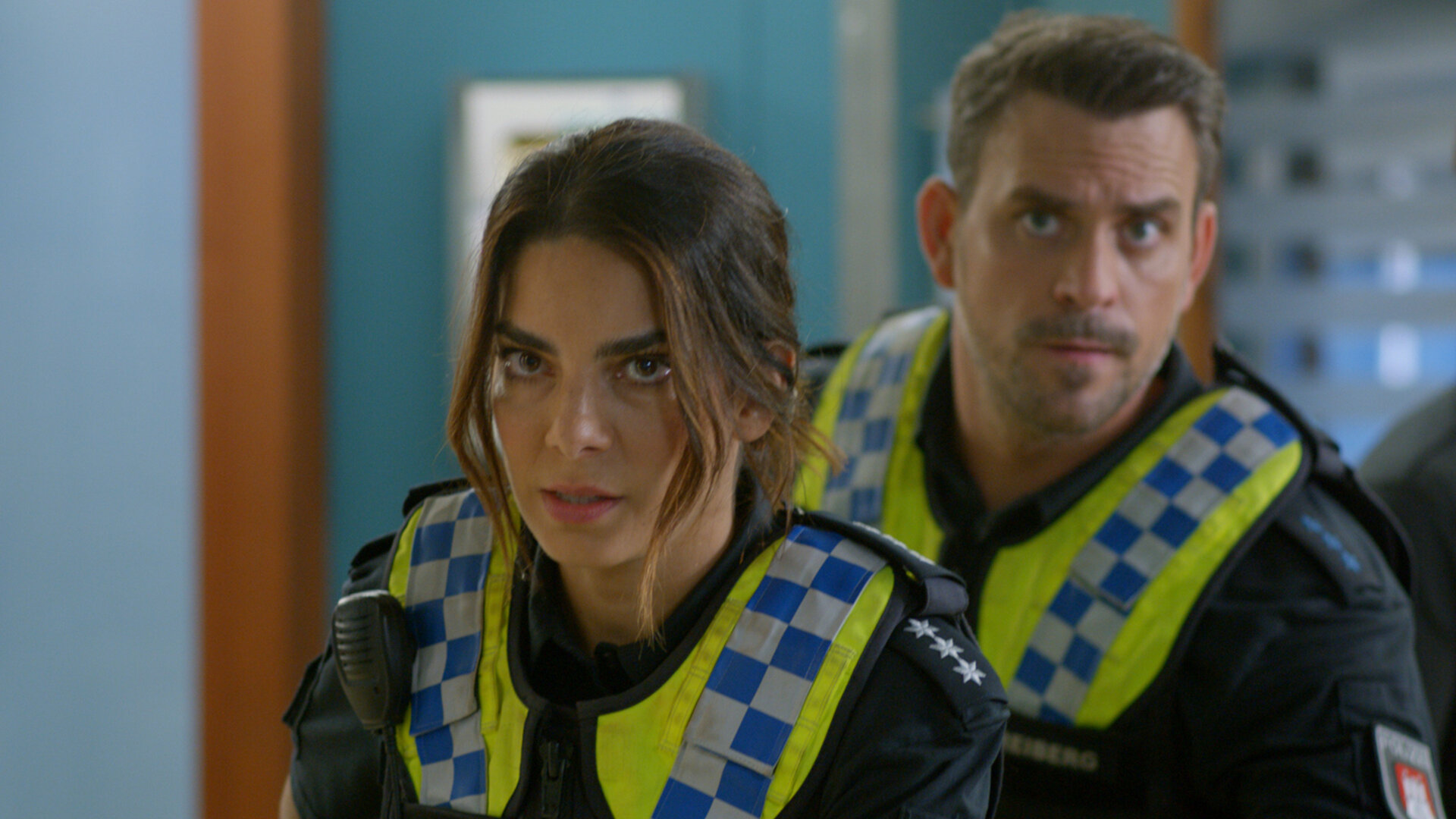 "Notruf Hafenkante - Allein gelassen": Großaufnahme: Polizistin Isa Nowak (Lilli Hollunder) und ihr Kollegen Kris Freiberg (Marc Barthel) stehen dicht hintereinander auf dem Gang des EKH.