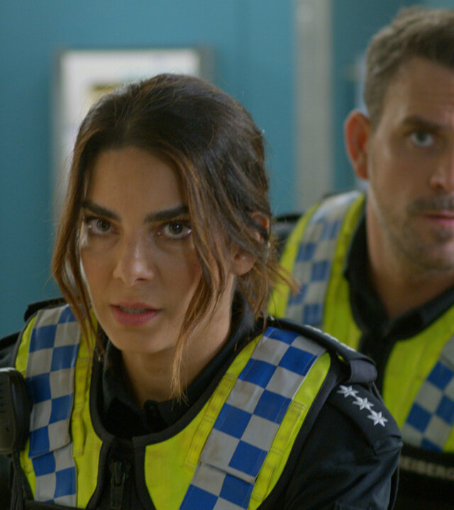 "Notruf Hafenkante - Allein gelassen": Großaufnahme: Polizistin Isa Nowak (Lilli Hollunder) und ihr Kollegen Kris Freiberg (Marc Barthel) stehen dicht hintereinander auf dem Gang des EKH.