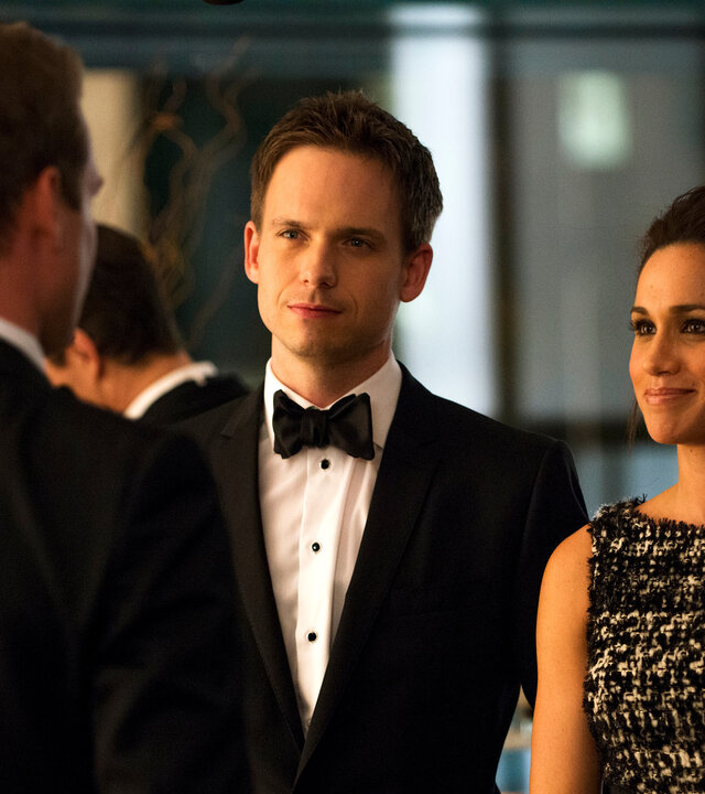 "Suits - Krieg": Mike (Patrick J. Adams) und Rachel (Meghan Markle) stehen nebeneinander und blicken lächelnd zu Harvey (Gabriel Macht), der ihnen gegenübersteht. Alle drei tragen festliche Abendgarderobe.