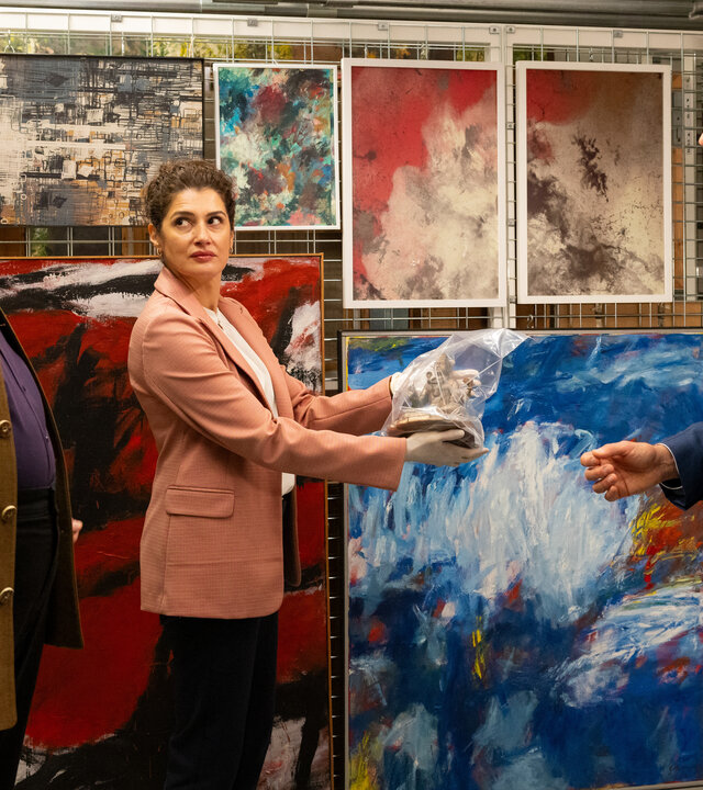 "Die Rosenheim-Cops - Ein Schwarm für Hansen": Kommissar Stadler (Dieter Fischer), Rechtsmedizinerin Dr. Dimos (Anastasia Papadopoulou) und Kommissar Hansen (Igor Jeftić) stehen um das Opfer (Komparsin) herum, das auf dem Boden liegt. Im Hintergrund hängen diverse moderne Gemälde.