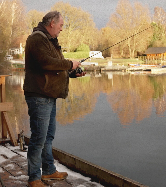 "Waldis Welt": Waldi steht auf einem Holzsteg an einem See und angelt.