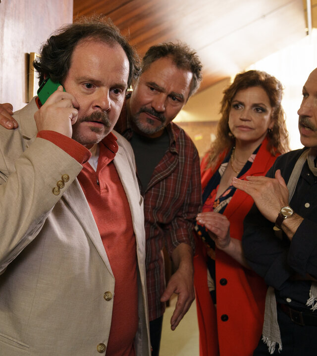 "SOKO Wien - Der große Mitsch": Michael Holzner "Mitsch" (Thomas Mraz), Markus Schäfer "Maschek" (Rainer Doppler), Bea Fux (Rebecca Immanuel) und Dietrich Kroll "Krolli" (Michael Fuith) stehen im Eingangsbereich einer Bar. Während Michael Holzner "Mitsch" telefoniert, sehen die anderen ihn neugierig und erwartungsvoll an.