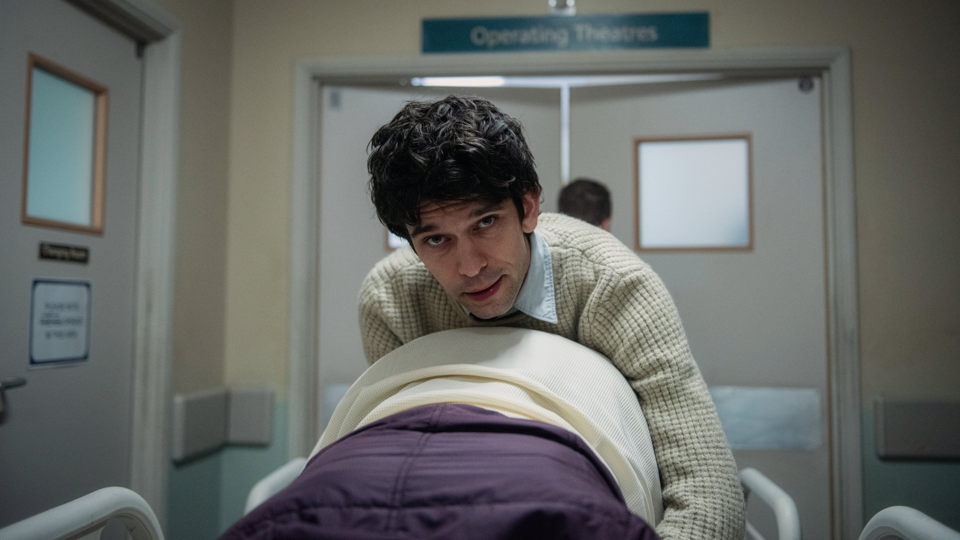 "This Is Going To Hurt - Ein Pint Gin": Adam Kay (Ben Whishaw) kniet auf einer Trage über einer schwangeren Frau und schaut angestrengt nach vorne.