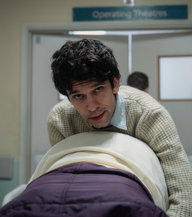 "This Is Going To Hurt - Ein Pint Gin": Adam Kay (Ben Whishaw) kniet auf einer Trage über einer schwangeren Frau und schaut angestrengt nach vorne.