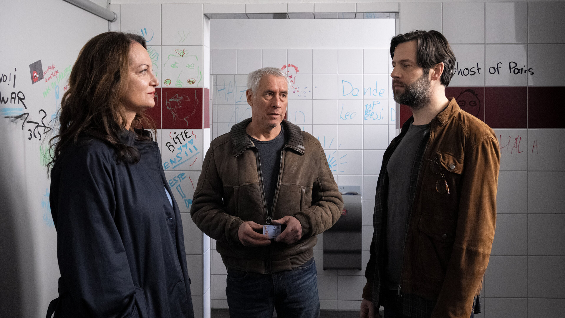 "Unter anderen Umständen - Dominiks Geheimnis": Jana Winter (Natalia Wörner), Matthias Hamm (Ralph Herforth) und Gustav Mikkelsen (Richard Ulfsäter) stehen zusammen in einer Schülertoilette.