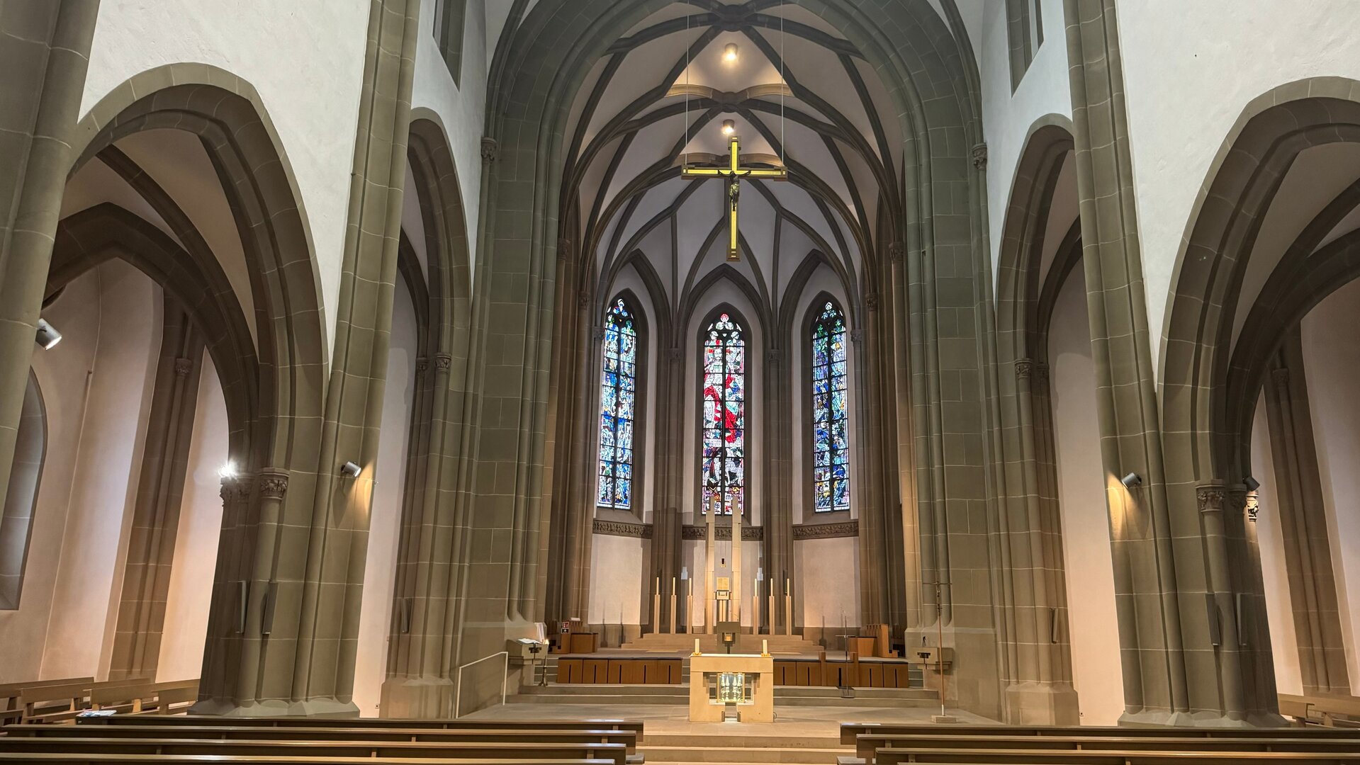 "Katholischer Gottesdienst - In der Liebe Gottes?!": Innenansicht auf den Altar und die Buntfenster der Stadtpfarrkirche Herz Jesu in Bad Kissingen.