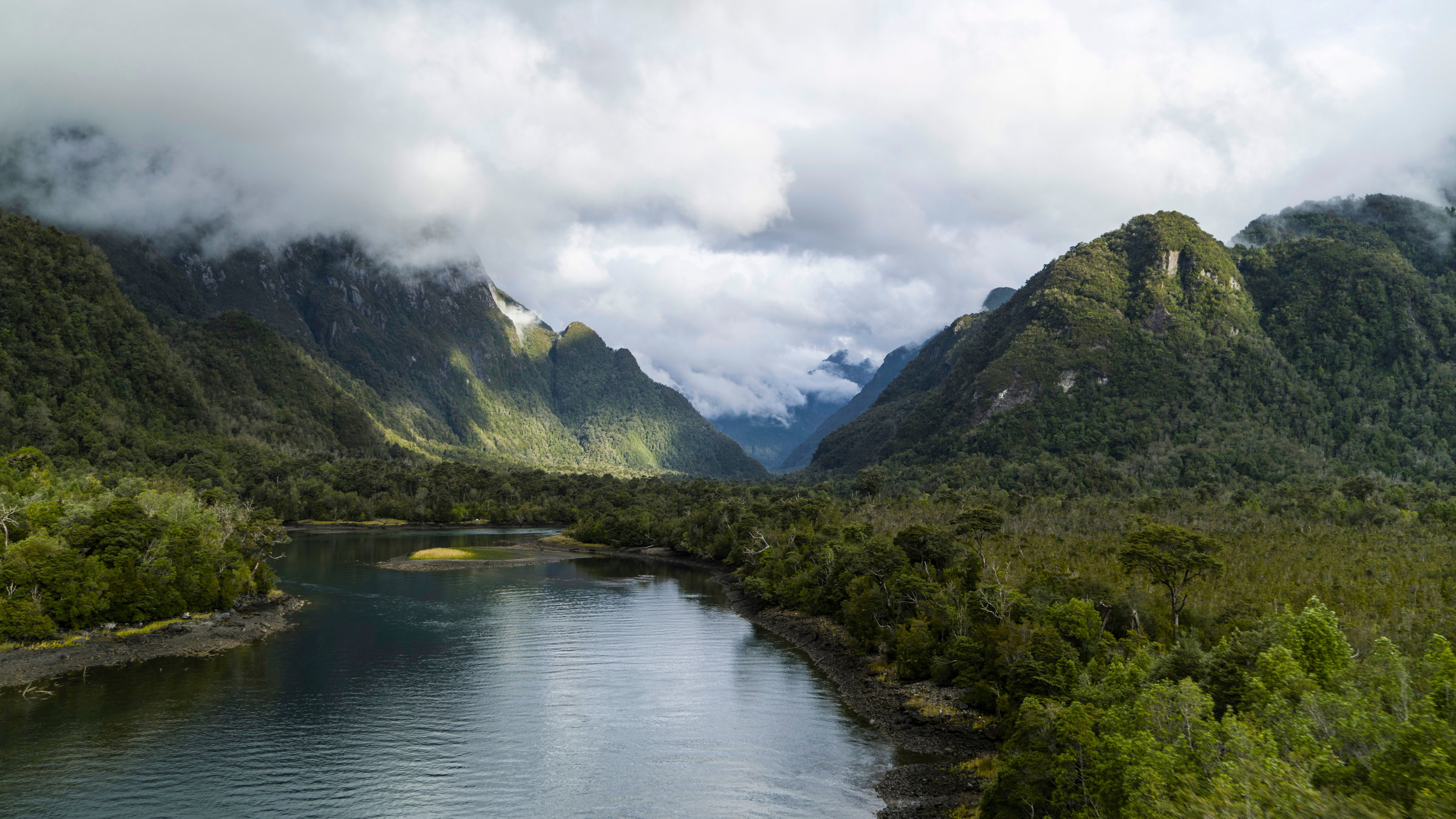 "Der Humboldt-Strom (1/3) - Das wilde Patagonien:  Fjord, bewaldete Hänge, viele Wolken.