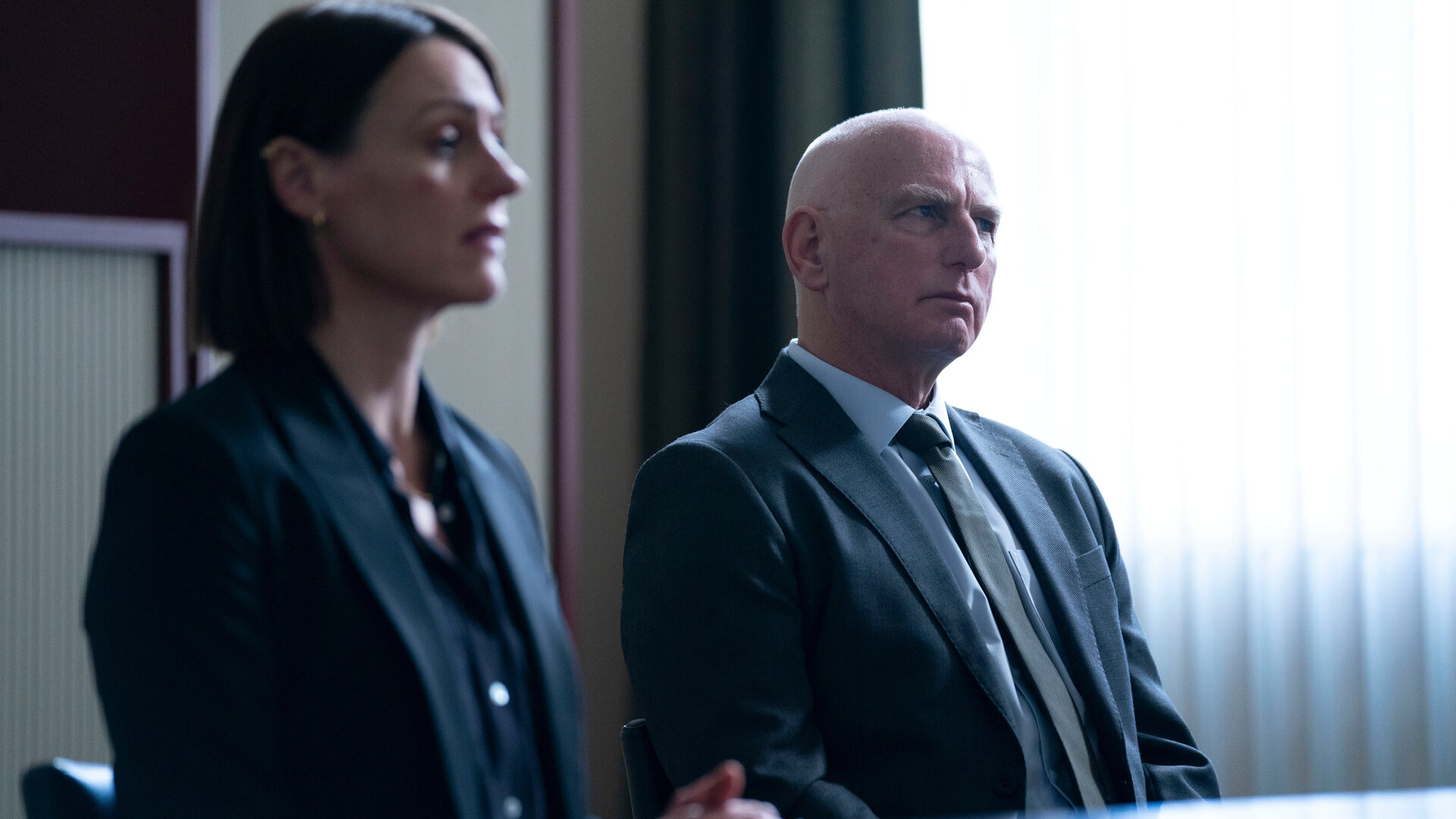 "Vigil - Tödliche Drohnen: Hochverrat": DCI Amy Silva und DSU Robertson (Gary Lewis) sitzen in einem Büroraum an einem Tisch.