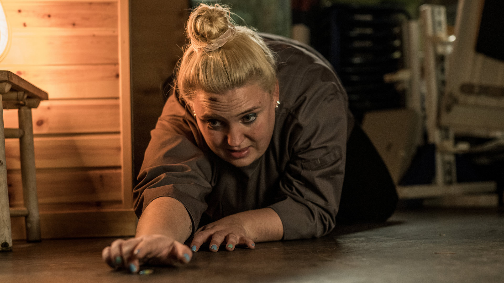"Elvira - Undercover": Elvira (Sara Klein) liegt auf dem Boden und streckt sich nach einem Fingernagel, der auf dem Boden liegt.