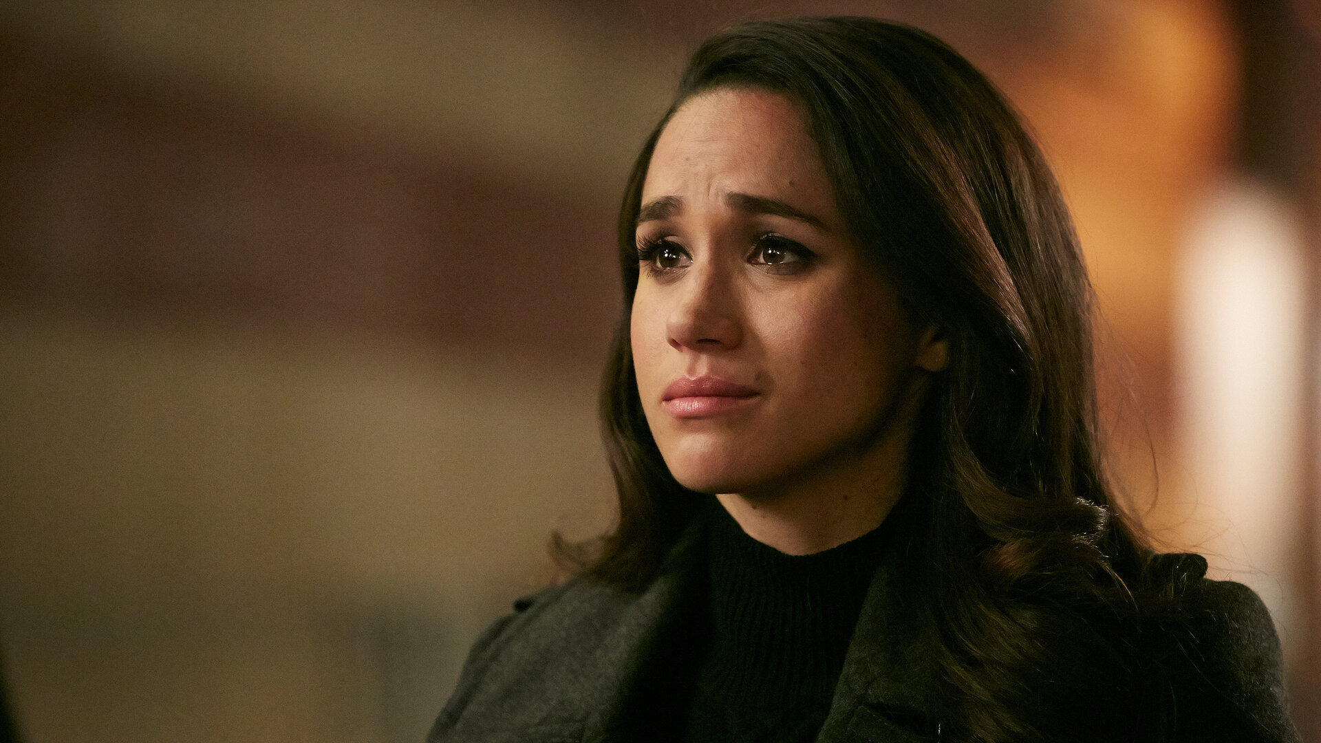"Suits - Chaostage": Porträtaufnahme: Rachel (Meghan Markle) schaut verzweifelt zur Seite und ist dunkel gekleidet.