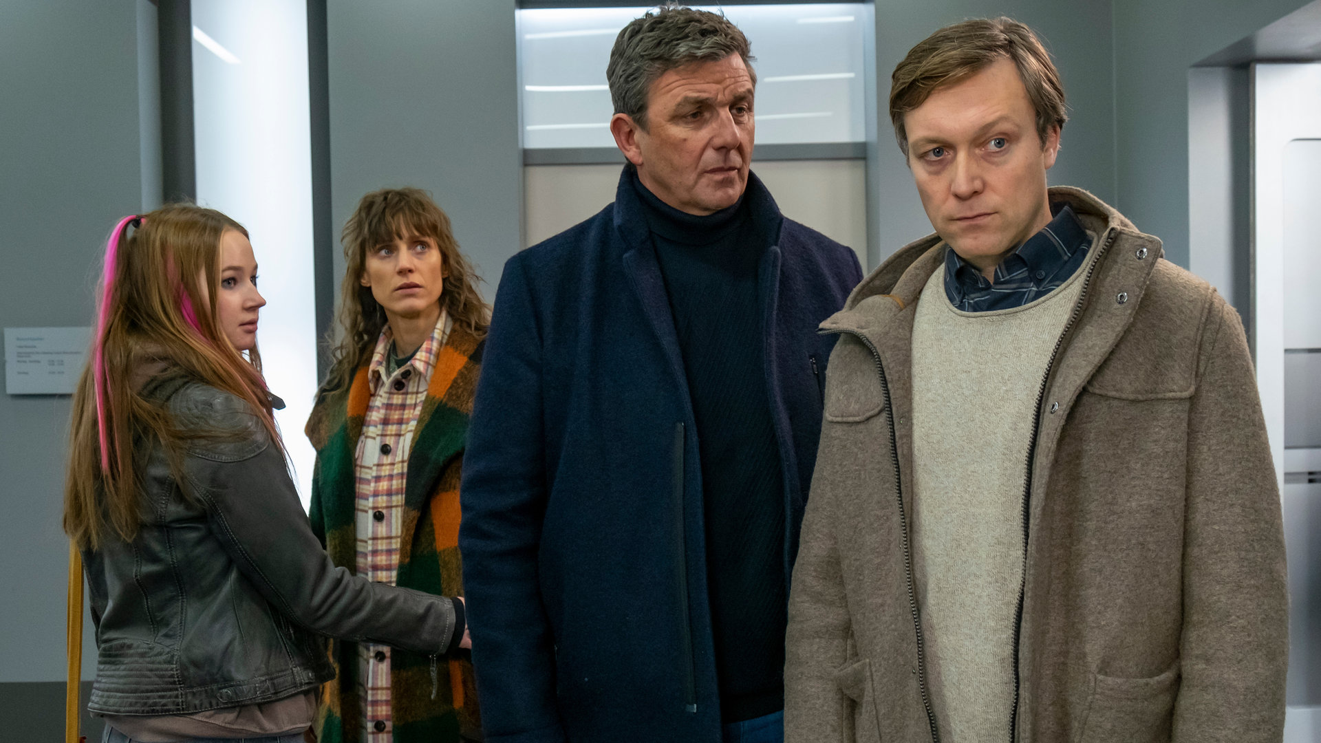 "Der Bergdoktor: Was bleibt (2)": Im Krankenhausflur stehen Dr. Martin Gruber (Hans Sigl) und Christoph Angerer) nachdenklich zusammen. Im Hintergrund blickt Katharina Bichler (Sophie Lutz) fassungslos zu den beiden, während Maja (Lorna zu Solms) sie am Arm festhält.