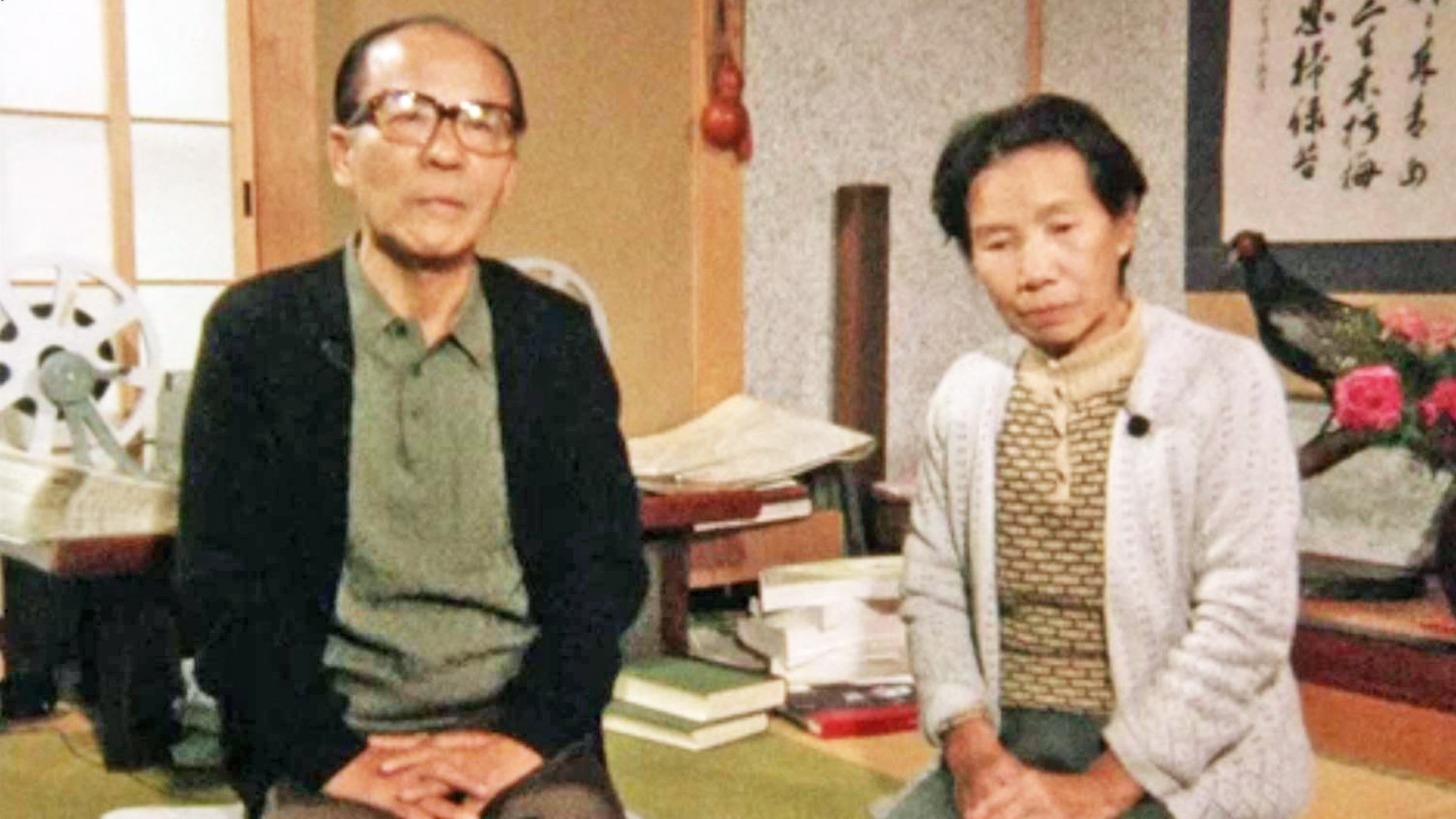 "Hiroshima, Nagasaki - Atombombenopfer sagen aus": Ein japanischer Mann (links) und eine Frau (rechts) sitzen mit gefalteten Händen auf dem Boden und blicken in die Kamera.