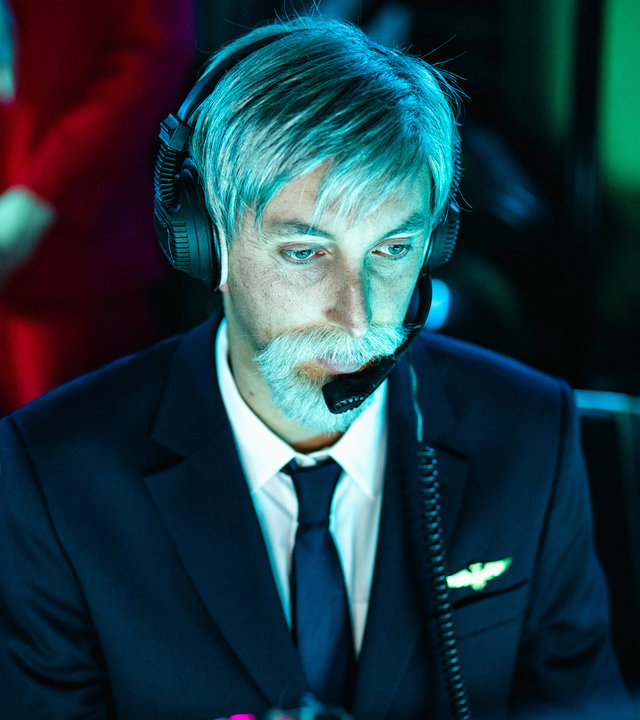 "Einsame Herzen - Folge 6": Roger (Torge Oelrich) sitzt in einer Pilotenuniform und einem Headset am Computer.