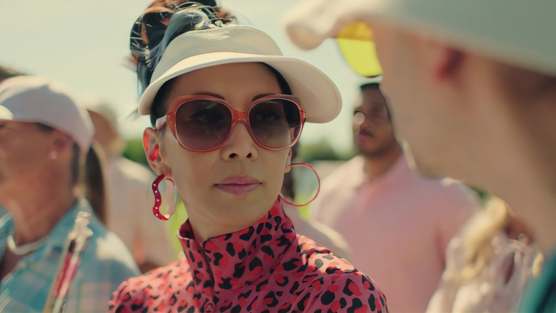 "Doppelhaushälfte - Golfkrieg": Tracy (Minh-Khai Phan-Thi) auf dem Golfplatz. Sie trägt eine weiße Kappe und eine große Sonnenbrille.