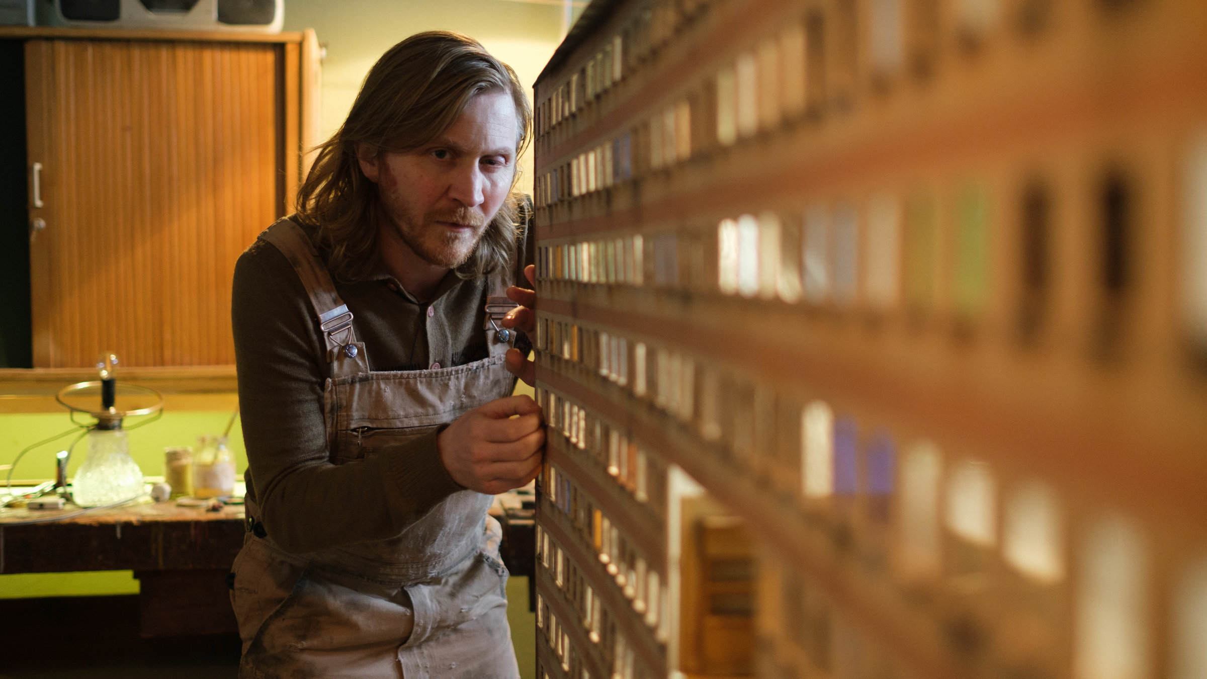 „KlassiXS – die großen Dramen in jungen Kurzfilmen: Auf Platte“: Hugo (Benjamin Kramme) bastelt an einem Miniaturhochhaus aus Holz.