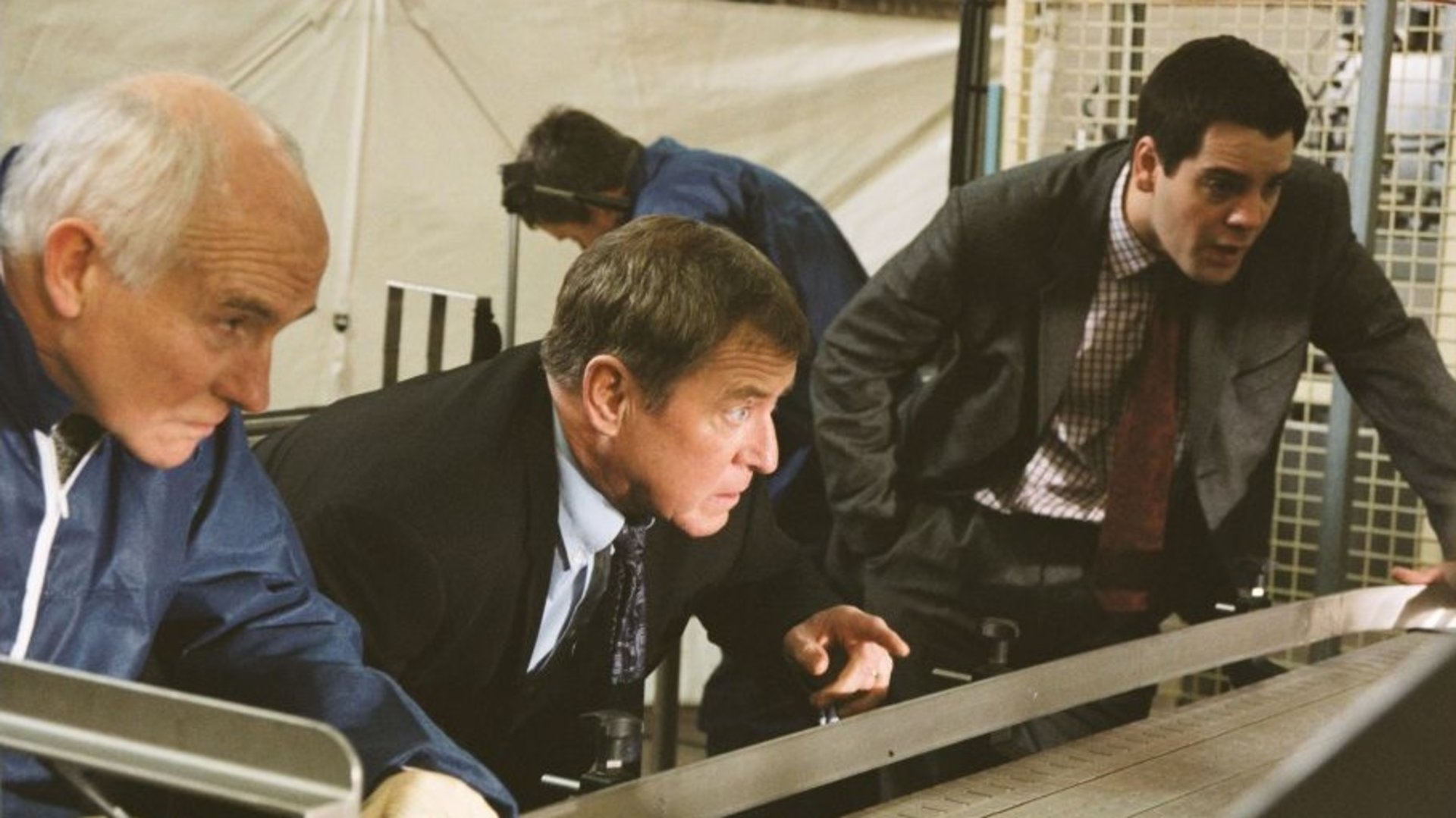 "Inspector Barnaby - Die Leiche ist heiß": Dr. Bullard (Barry Jackson), Inspector Barnaby (John Nettles) und DS Dan Scott (John Hopkins) in Nahaufnahme, wie sie konzentriert etwas beobachten.