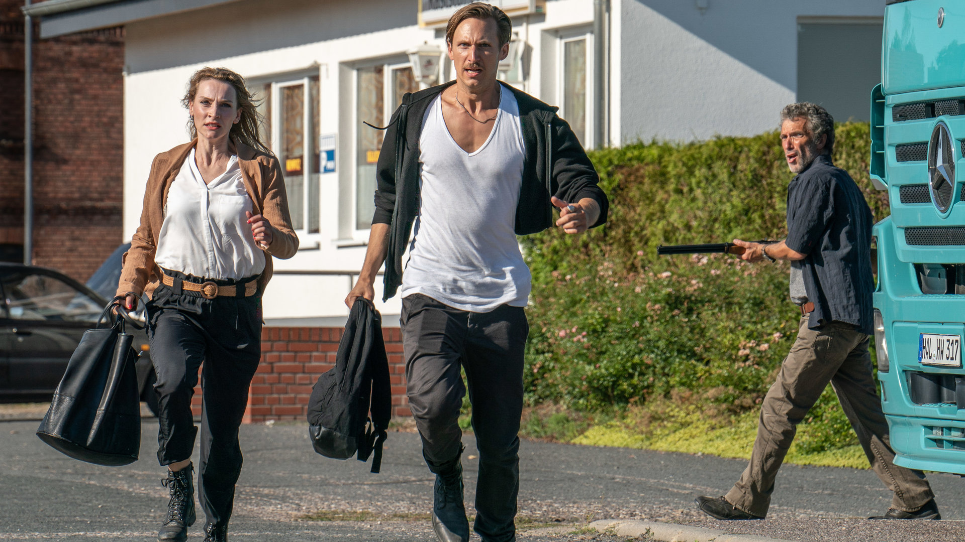 "SOKO Leipzig - Das ewige Leben (1)": Candy (Jana Klinge) und Moritz Brenner (Johannes Hendrik Langer) laufen vor dem mit einer Schrotflinte bewaffneten Trucker (Stefan Lochau) davon.