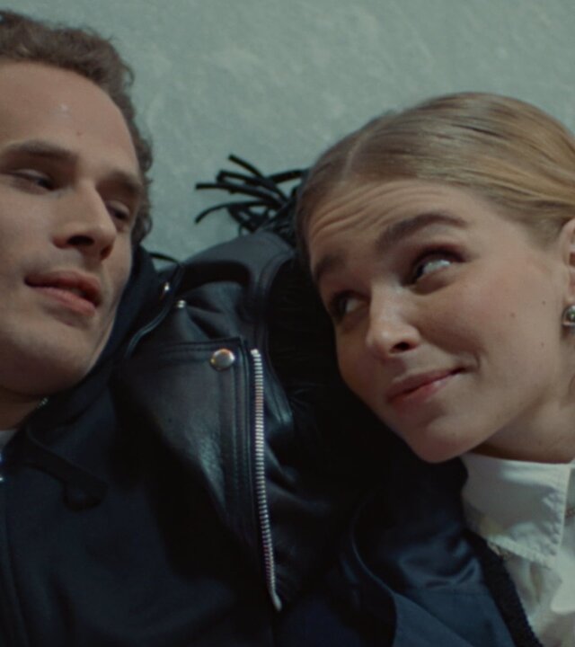 "Single Bells - 12 Dates till Christmas: Jens I": Jens (Flor Van Severen) und Mina (Julie Van den Steen) liegen nebeneinander im Schnee. Jens hat seinen Arm um Mina gelegt. Beide schauen sich verliebt an.