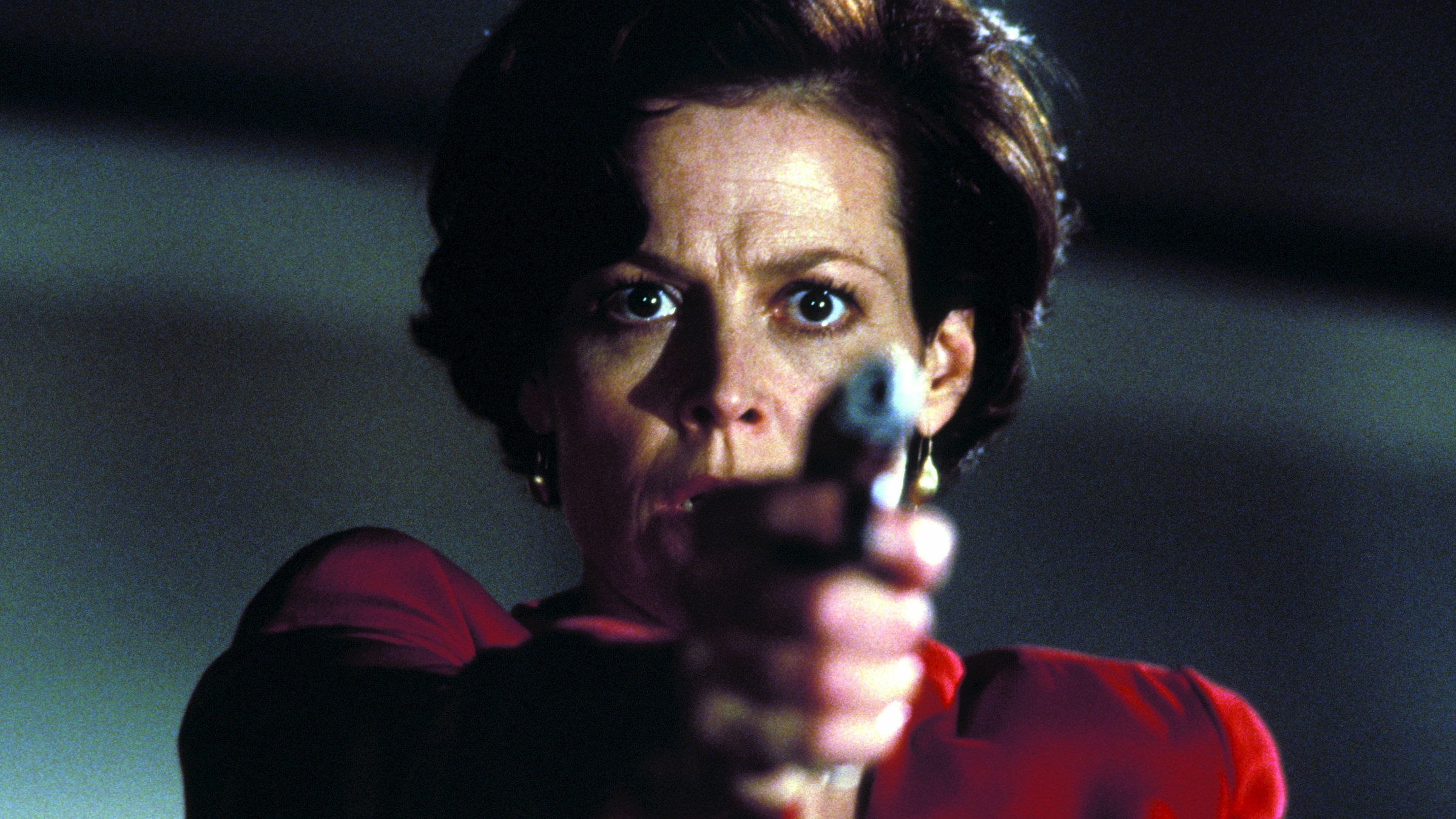 "Copykill": Helen Hudson (Sigourney Weaver) ist in der Nahaufnahme zu sehen, wie sie ängstlich nach vorn blickt und eine Waffe auf ihr Gegenüber richtet.