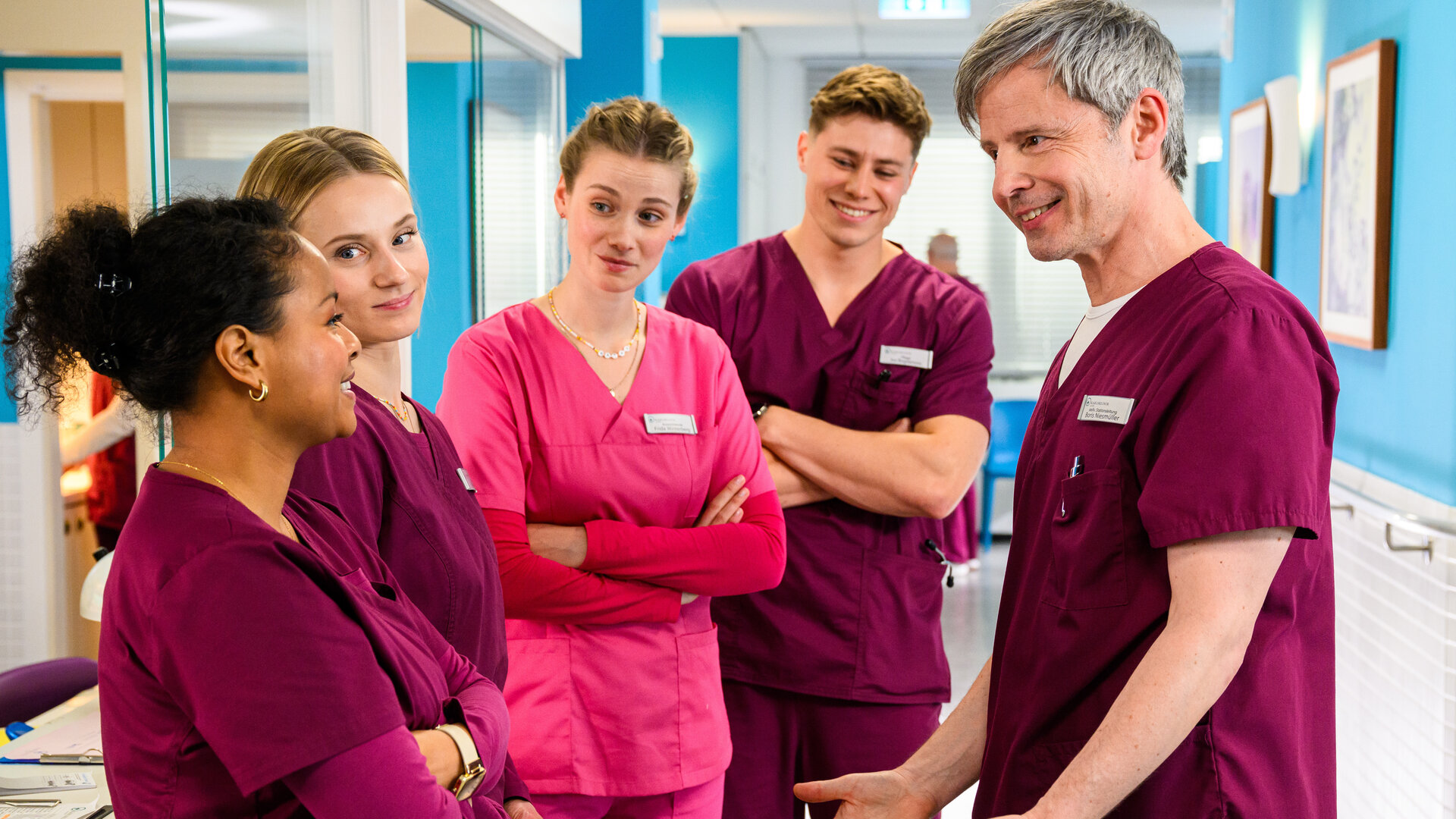 "Bettys Diagnose - Eifersüchtig": Zoe Breitner (Catherine Chikosi), Mia Kunze (Antonia Döring), Frida Winterberg (Johanna Hens), Ivo Bogdanović (Oscar Nadermann) und Boris Niesmüller (Matthias Bundschuh) stehen im Krankenhausflur nebeneinander und schauen sich an.