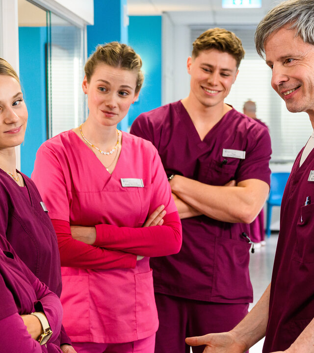 "Bettys Diagnose - Eifersüchtig": Zoe Breitner (Catherine Chikosi), Mia Kunze (Antonia Döring), Frida Winterberg (Johanna Hens), Ivo Bogdanović (Oscar Nadermann) und Boris Niesmüller (Matthias Bundschuh) stehen im Krankenhausflur nebeneinander und schauen sich an.