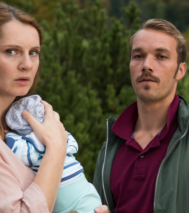 "Lena Lorenz - Eindeutig uneindeutig": Nina Cramer (Daniela Schulz) hält ein Baby im Arm. Neben ihr steht Thomas Cramer (Max Woelky). Beide blicken ernst.