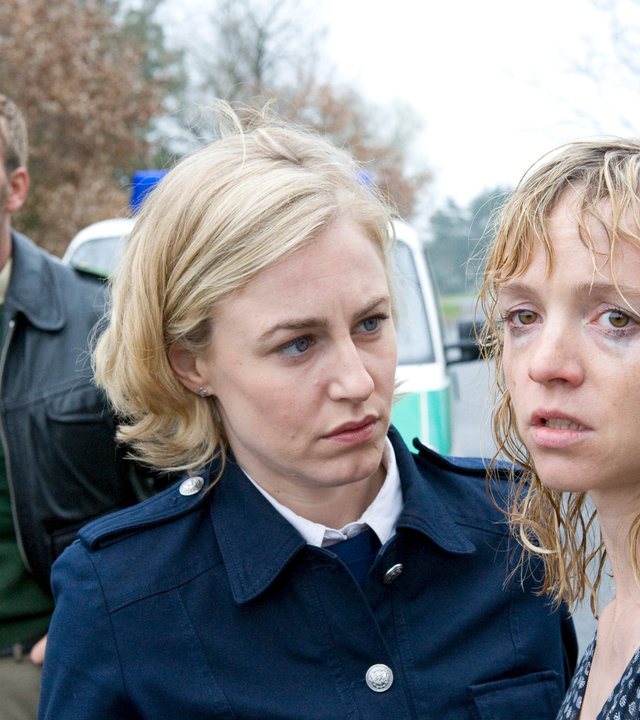 "SOKO Wismar - Die Schläfer": Auf einer Landstraße versucht Leena (Li Hagman) eine verwirrte, völlig durchnässte junge Frau (Johanna Klante) zu beruhigen. Pöhlmann (Dominic Boeer) ist ebenfalls aus dem Dienstfahrzeug ausgestiegen und versucht mit Blicken zu ergründen, wovor die junge Frau geflohen ist.