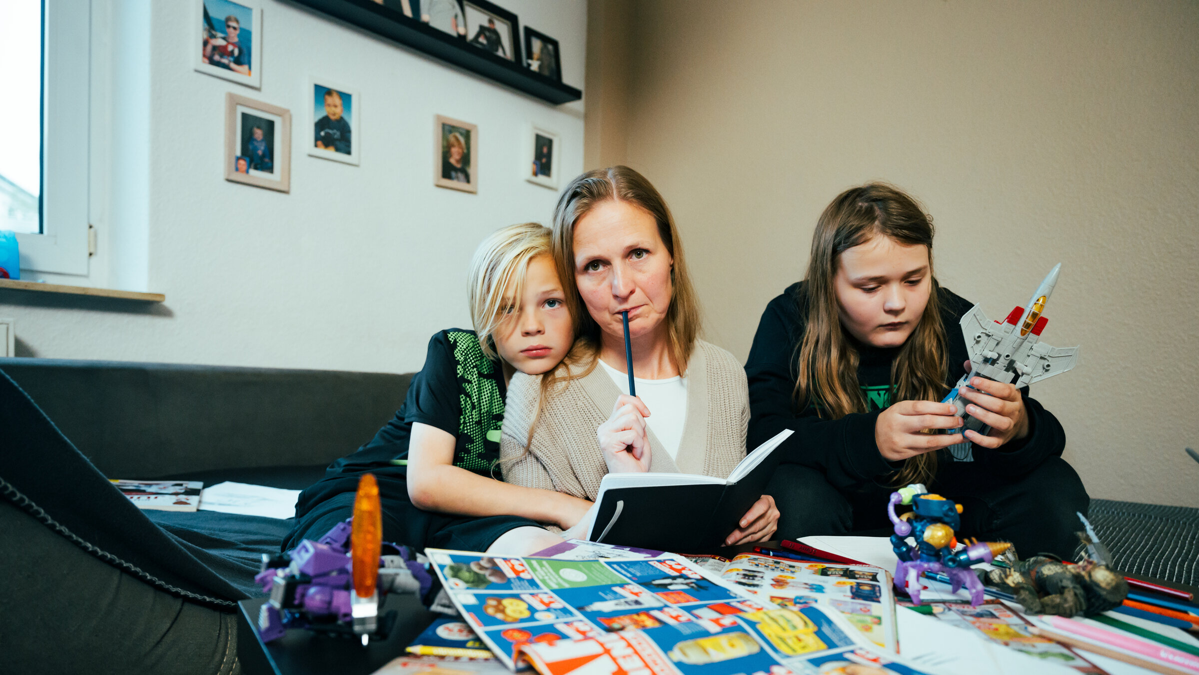 "Eine für alles - Armutsrisiko alleinerziehender Mutter": Cindy sitzt mit zwei ihrer vier Kinder zu Hause in ihrer Wohnung in Oldenburg auf dem Sofa.
