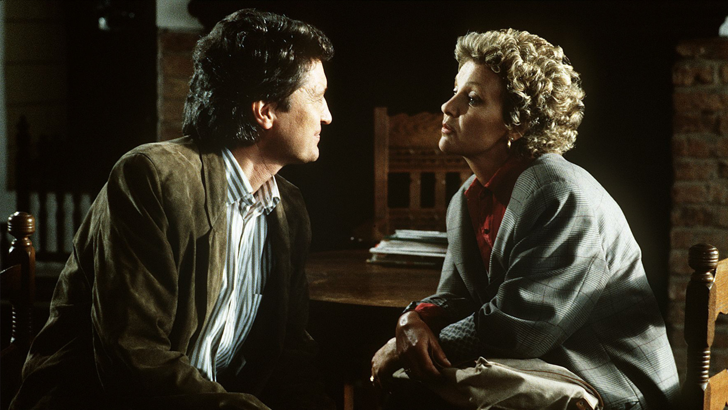 "Der Landarzt - Der Spieler": Dr. Mattiesen (Christian Quadflieg) und Annemarie (Gila von Weitershausen) sitzen sich in einem dunklen Raum gegenüber und schauen sich besorgt in die Augen.