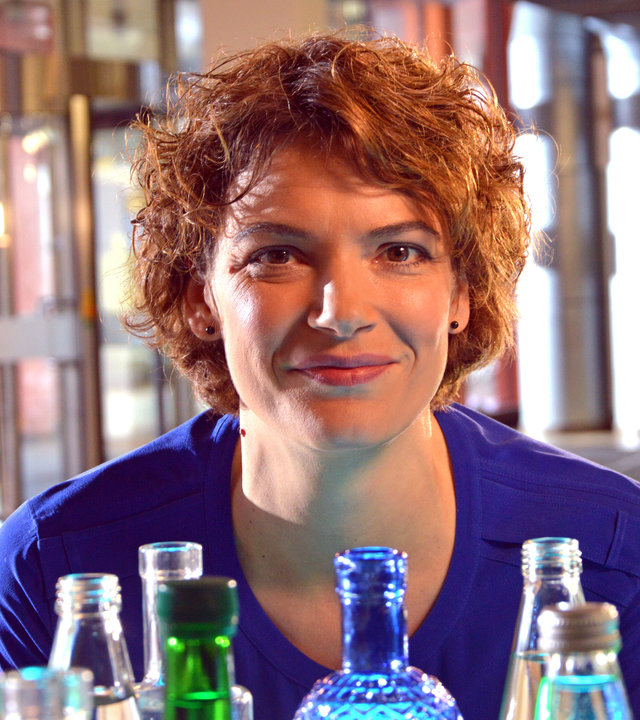 "Terra Xpress: Zeit für gutes Wasser": Moderatorin Lena Ganschow in Großaufnahme hinter verschiedenen Flaschen.