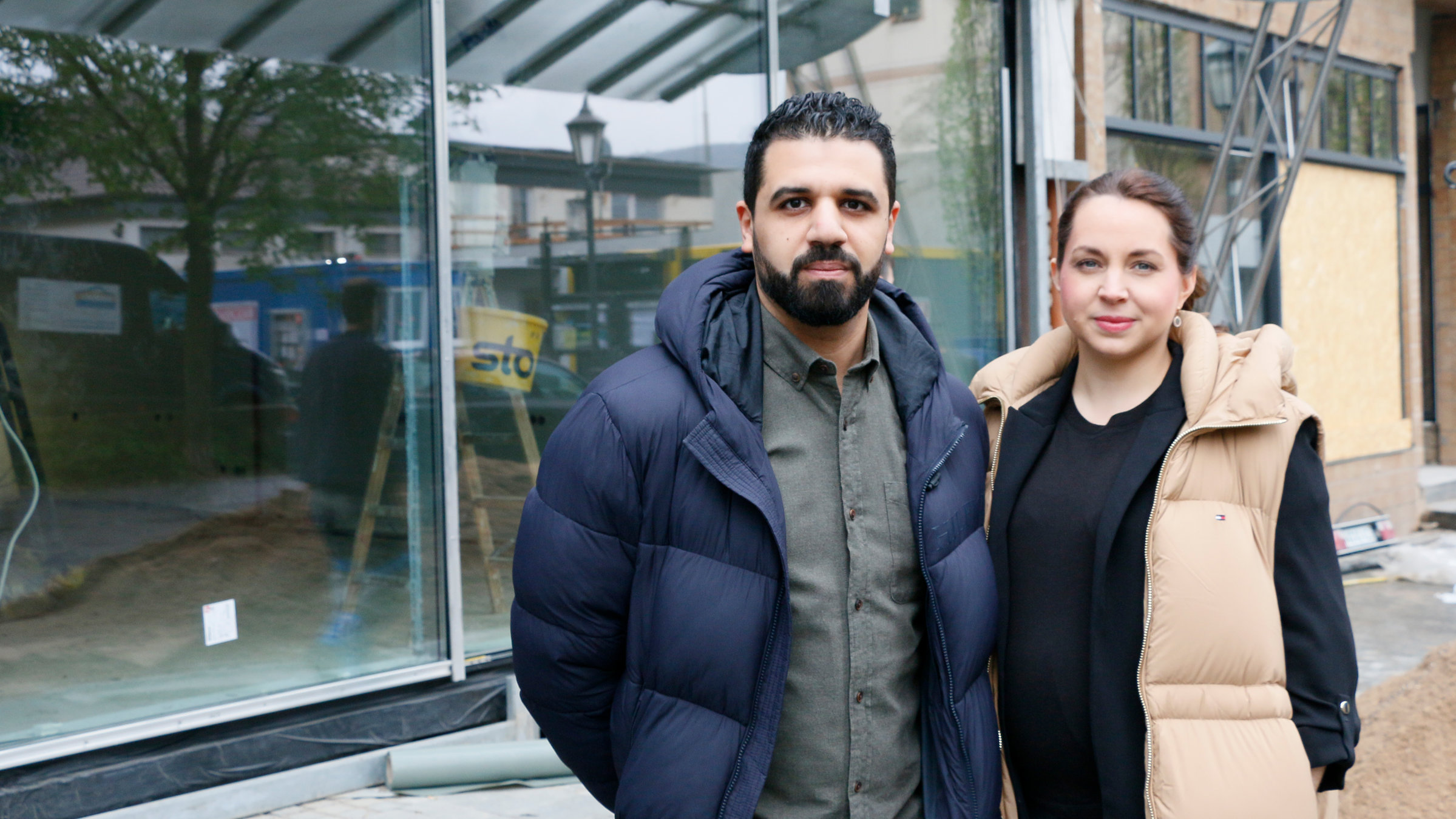 "37°: Was wir retten konnten - Zwei Jahre nach der Flutkatastrophe": Nora steht mit ihrem Mann Soufyan Nechad vor ihrem neuen Optikergeschäft: Beide schauen zur Kamera.