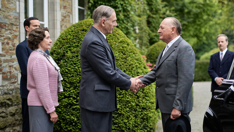 "An einem Tag im September": Charles de Gaulle (Jean-Yves Berteloot) und Konrad Adenauer (Burghart Klaußner) stehen sich vor dem Landhaus gegenüber und begrüßen sich mit einem Handschlag. Hinter de Gaulle stehen seine Frau Yvonne (Hélène Alexandridis) und sein Sohn Philippe (Pierre Lognay) und beobachten das Ganze. Günther Bachmann (Fabian Busch) steht etwas abseits hinter Adenauer und sieht ebenfalls zu.