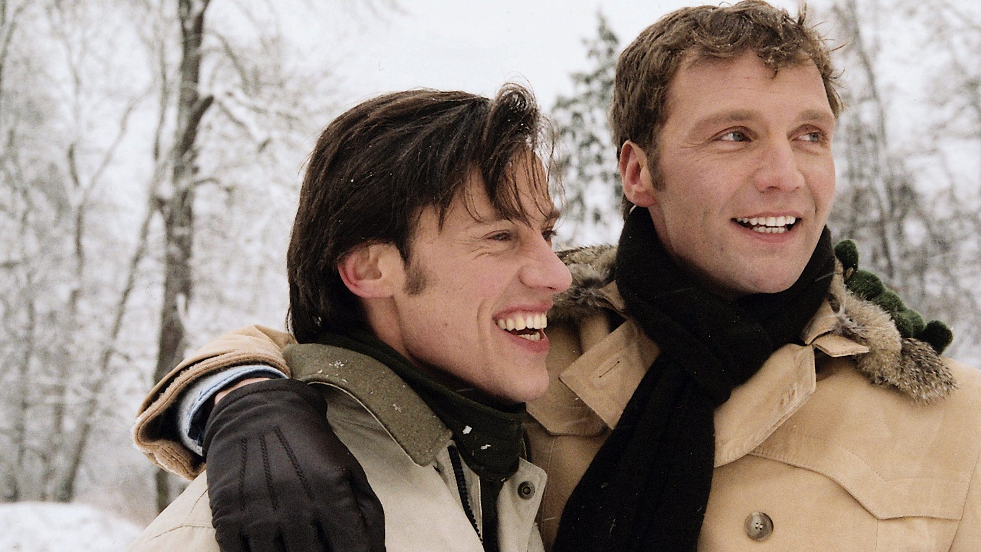 "Bianca - Wege zum Glück: Kapitel 106": In der Winterlandschaft: Oliver (Patrik Fichte) und Matthias (Andreas Hutzel) stehen nebeneinander und schauen in die Weite. Oliver legt seinen rechten Arm um Matthias. Beide wirken glücklich.