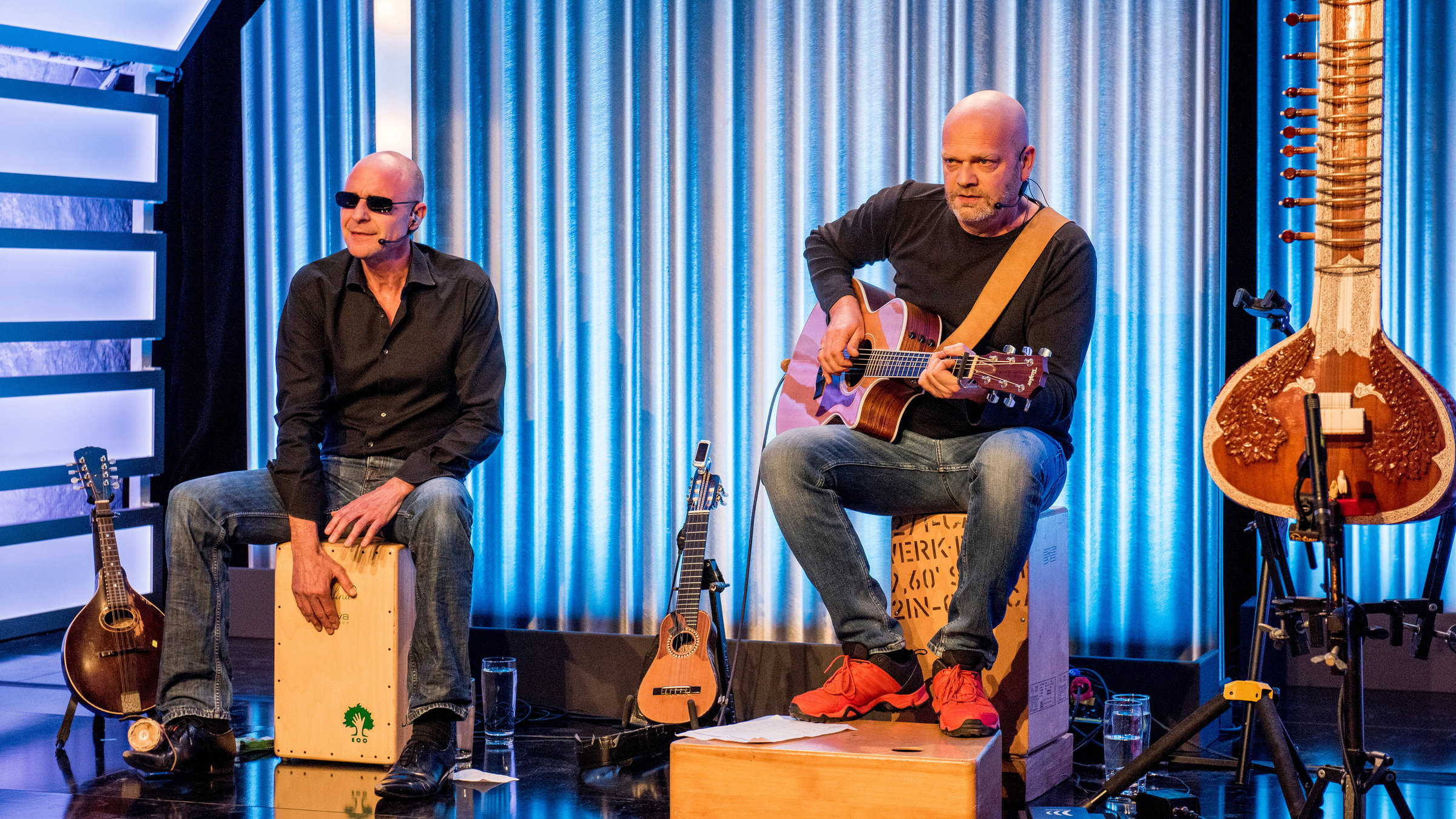 "die feisten: Adam & Eva": Mathias Zeh und Rainer Schacht sitzen auf der Bühne und machen Musik auf verschiedenen Instrumenten.