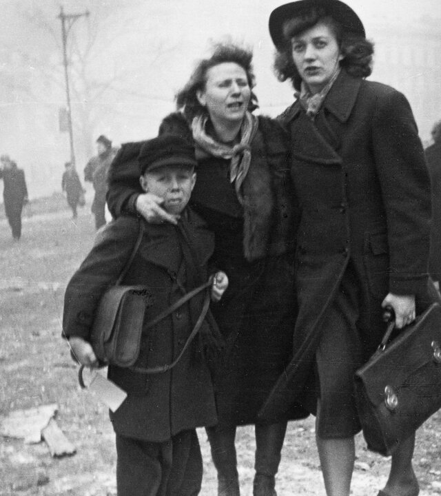 "Terra X History: Bomben über Deutschland": Schwarz-Weiß-Foto: Zwei Frauen und ein Junge stehen vor den Trümmern am Anhalter Bahnhof in Berlin nach einem Luftangriff im Februar 1945. Im Hintergrund laufen weitere Personen, Schutt liegt auf der Straße.