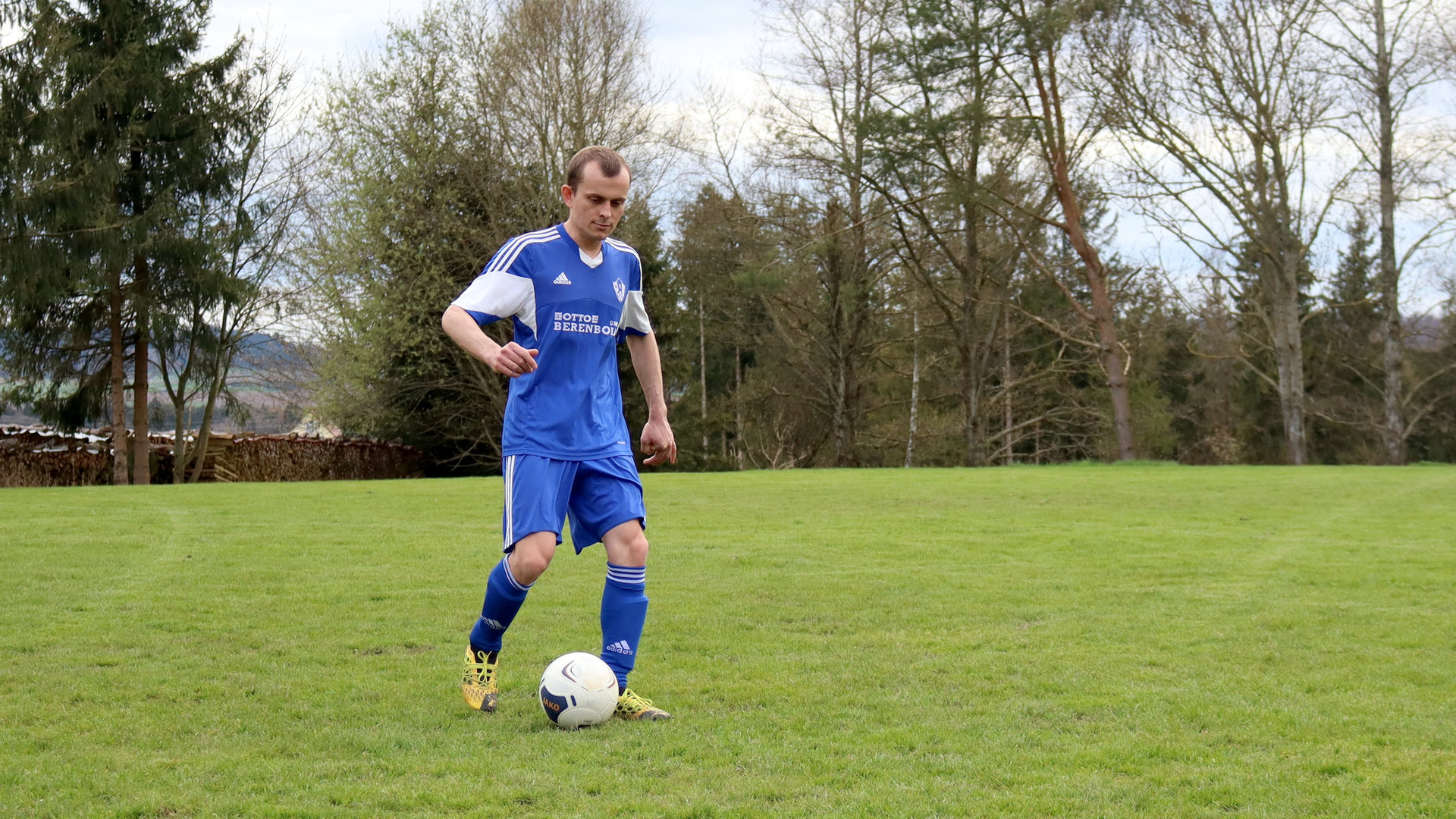 "einfach Mensch - Felix Jehle: Raus aus dem Abseits!": Felix Jehle beim Fußballspielen, er übt einen Torschuss auf dem Rasen.
