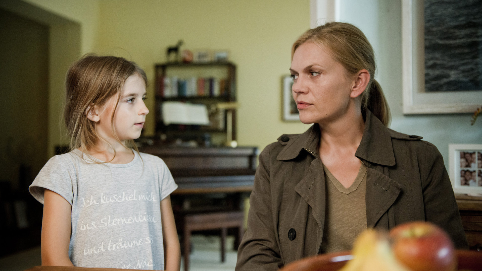 "Helen Dorn - Das dritte Mädchen": Elena Georgi (Milia Rütter) steht neben Helen Dorn (Anna Loos), die am Tisch sitzt.