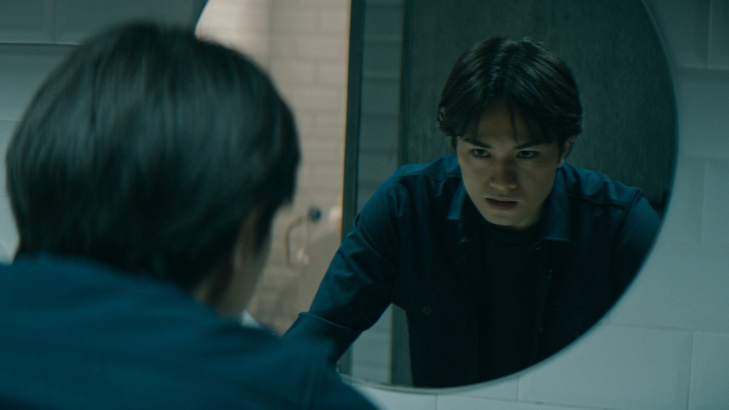 "Concordia - Tödliche Utopie (4) - Geheimnisse": A.J. Oba (Kento Nakajima) sieht sich im Spiegel an.