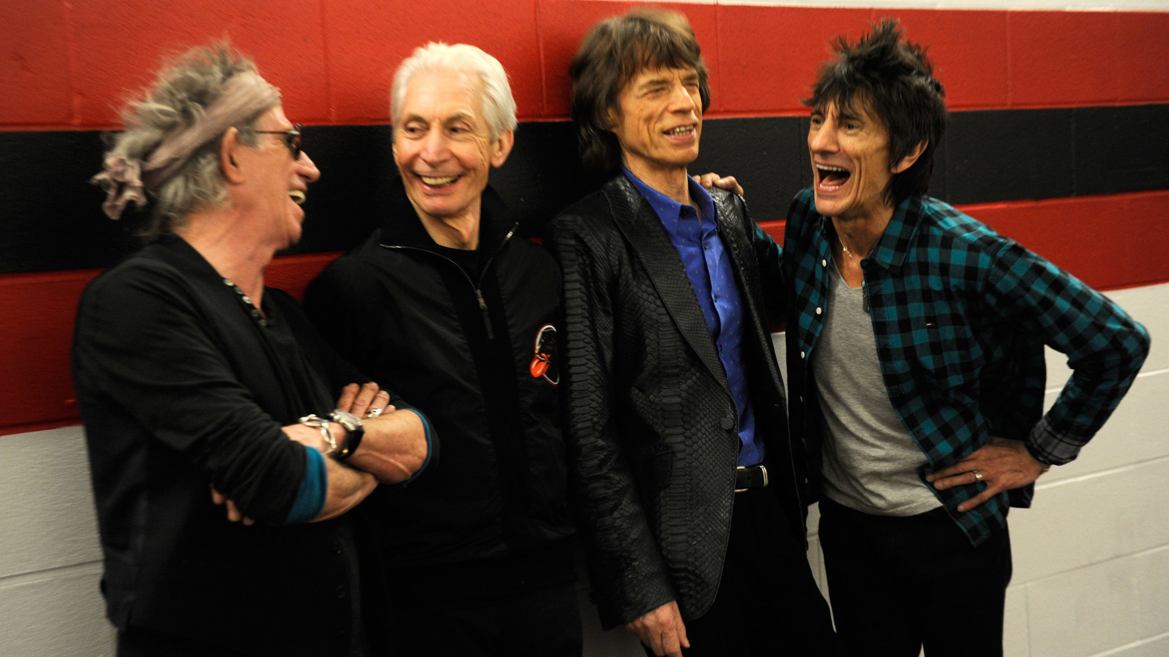 "The Rolling Stones: GRRR live!": Die vier Bandmitglieder stehen nebeneinander vor einer Wand. Sie unterhalten sich und lachen.