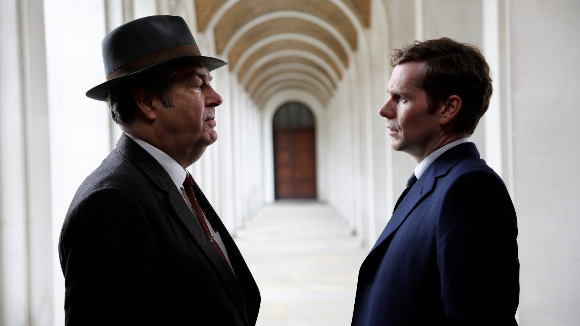"Der junge Inspektor Morse - Tödliche Noten": Fred Thursday (Roger Allam) und Inspektor Morse (Shaun Evans) stehen sich in einer offenen Vorhalle gegenüber und schauen sich entschlossen an.