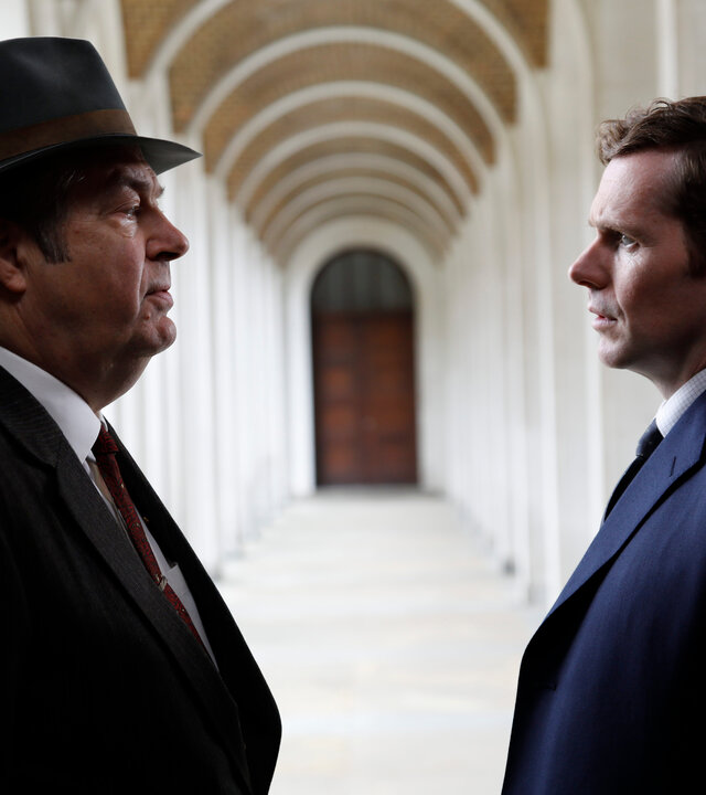 "Der junge Inspektor Morse - Tödliche Noten": Fred Thursday (Roger Allam) und Inspektor Morse (Shaun Evans) stehen sich in einer offenen Vorhalle gegenüber und schauen sich entschlossen an.
