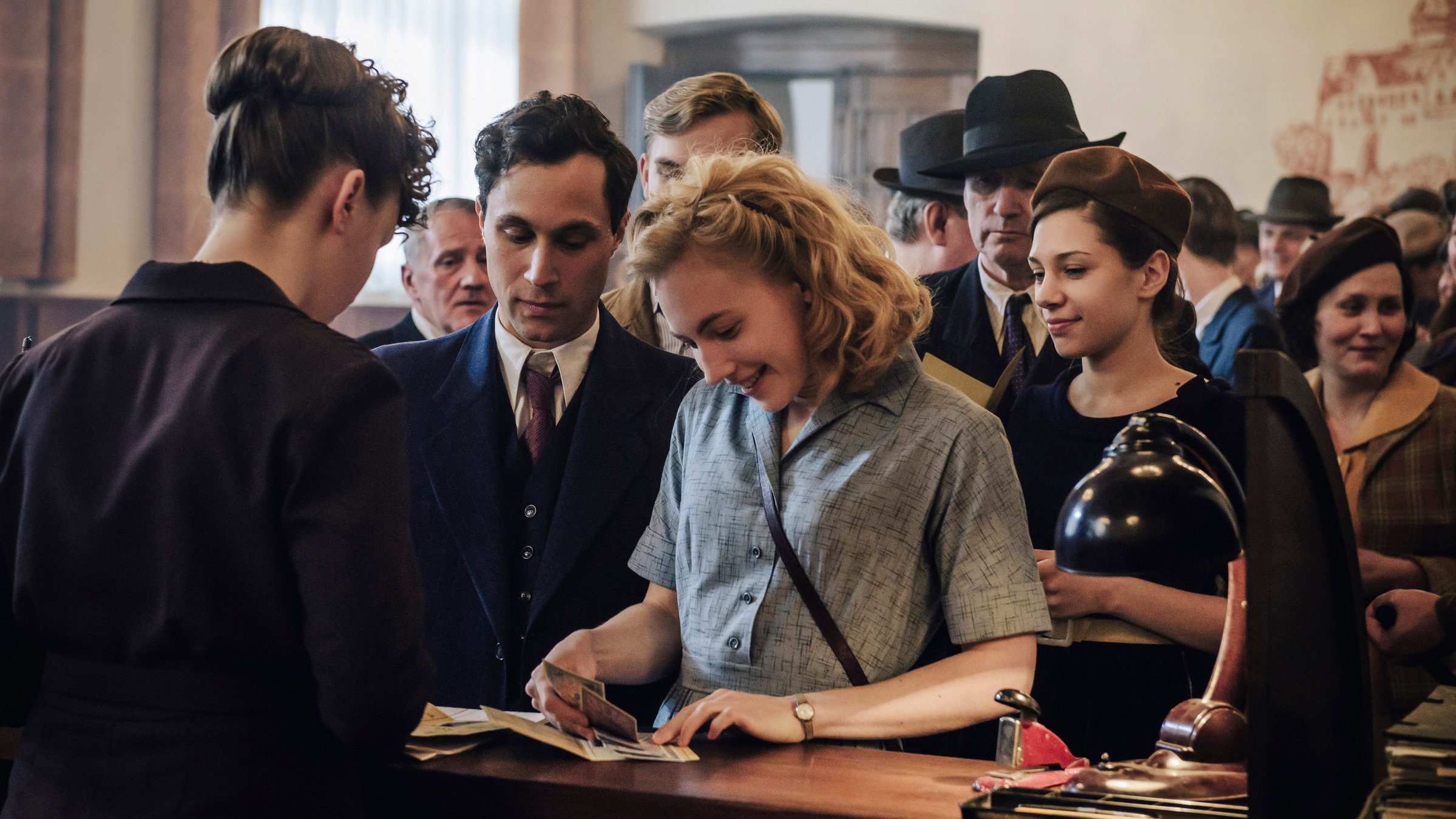 "Unsere wunderbaren Jahre (1/3)": 40 Druckfrische D-Mark für Jeden: Ulla Wolf (Elisa Schlott, mitte) und Jürgen Vielhaber (Ludwig Trepte, 2.v.l.) erhalten ihr "Kopfgeld".