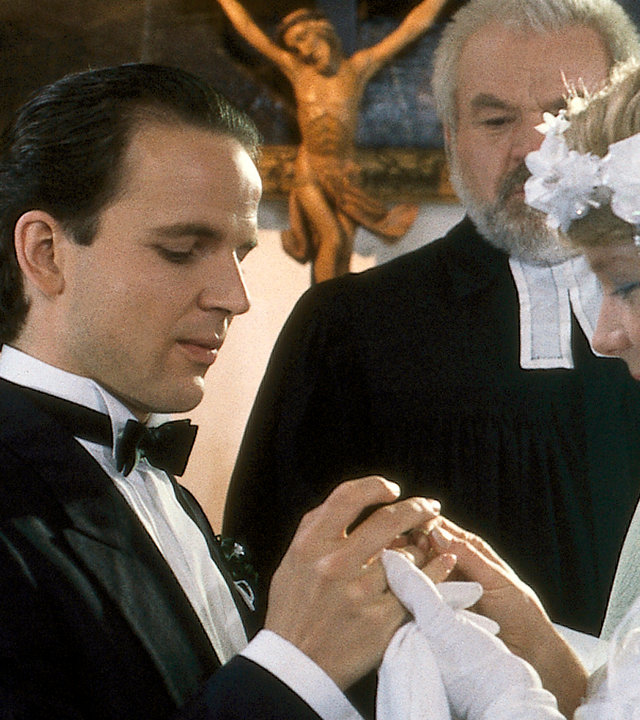 "Die Drombuschs - Die Gretchenfrage": In einer Kapelle stehen Chris (Mick Werup) und Tina (Marion Kracht) in Hochzeitskleidung und werden getraut.