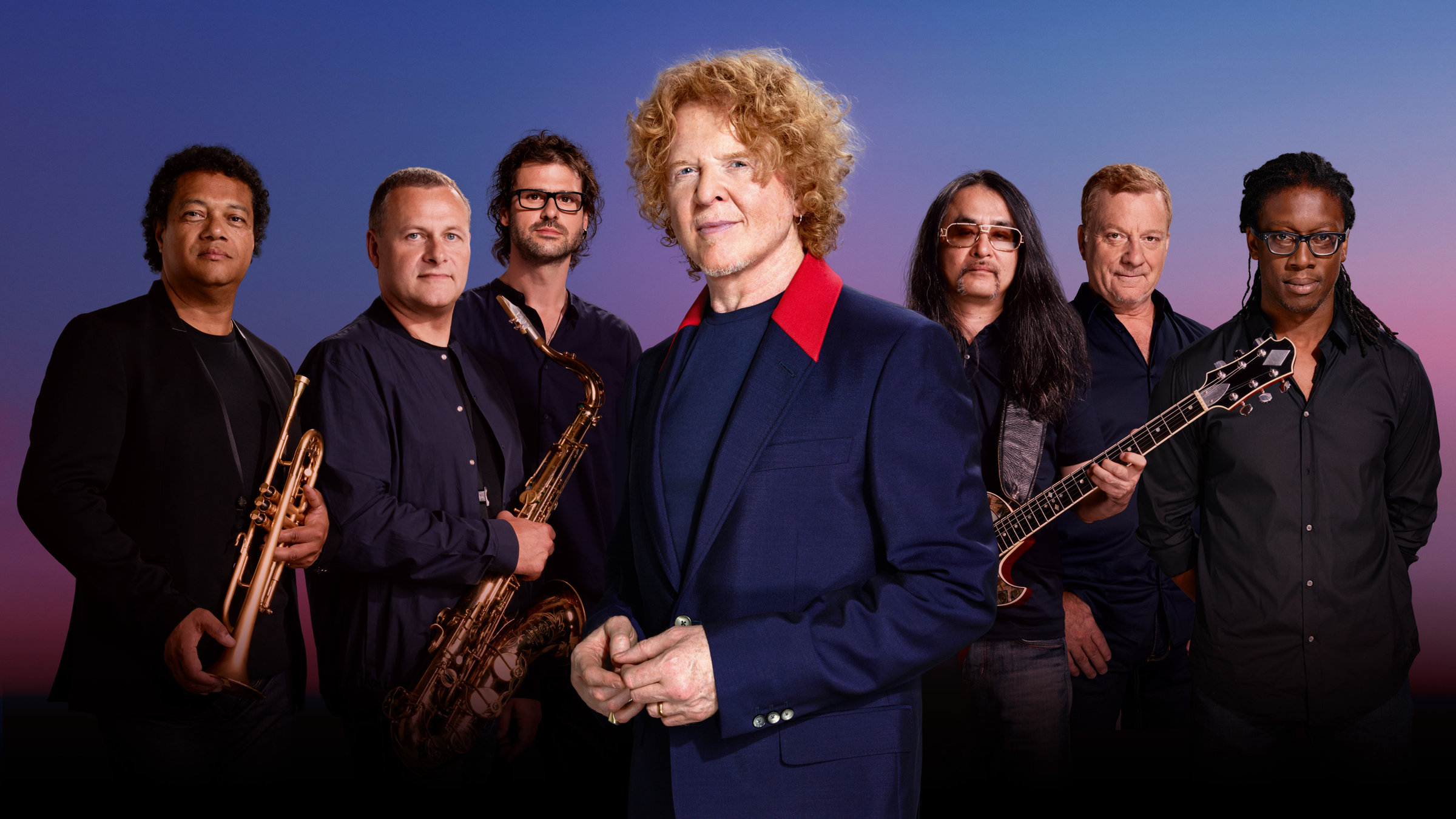 "Simply Red: Live at Old Trafford - Theatre of Dreams": Die sieben Mitglieder der Gruppe Simply Red stehen nebeneinander, der Sänger etwas im Vordergrund, alle gucken direkt in die Kamera.